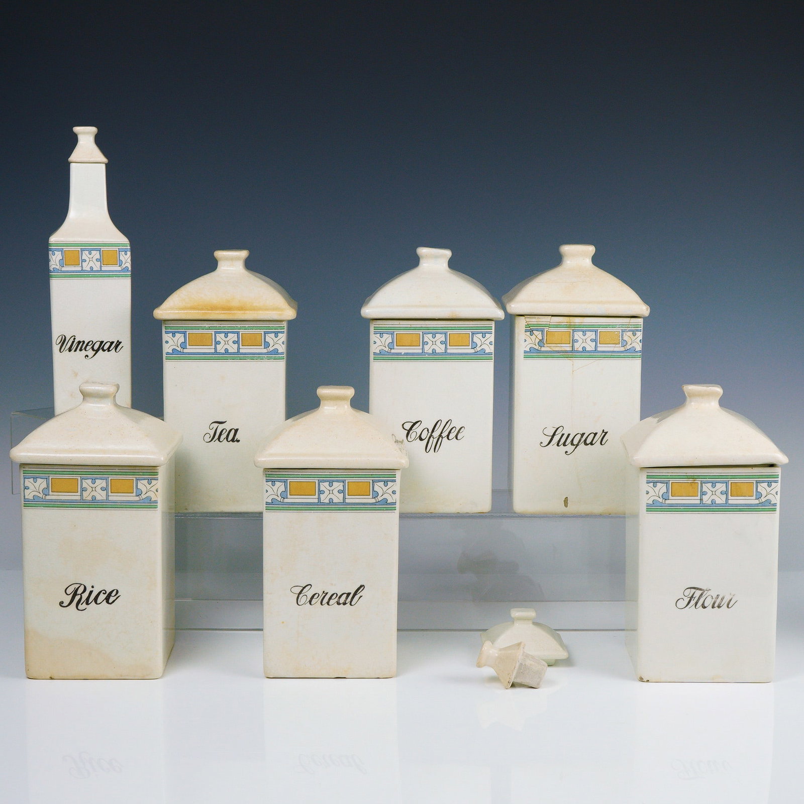 Art Deco Ceramic Kitchen Canister Set, Geometric Motif: A charming and complete vintage ceramic kitchen canister set dating to the early 20th century, beautifully decorated with a colorful Art Deco border of yellow, blue, and green geometric designs. This