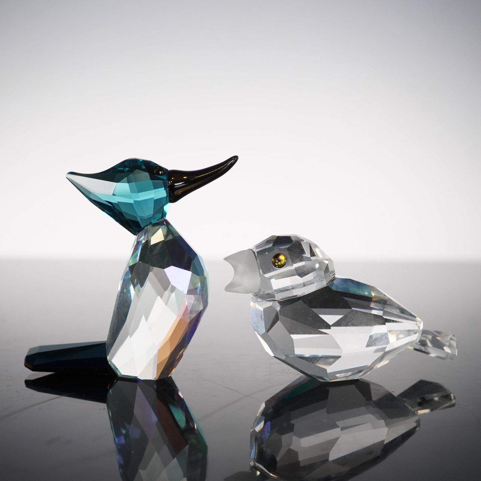 2pc Swarovski Crystal Bird Figurines: Two alluring bird figurines including Lovlots City Park Woodpecker 1036530 and Sparrow with Frosted Beak 169685. Ziggy's head is in Indicolite crystal, his body is in Light Azure and Aurora Borealis c