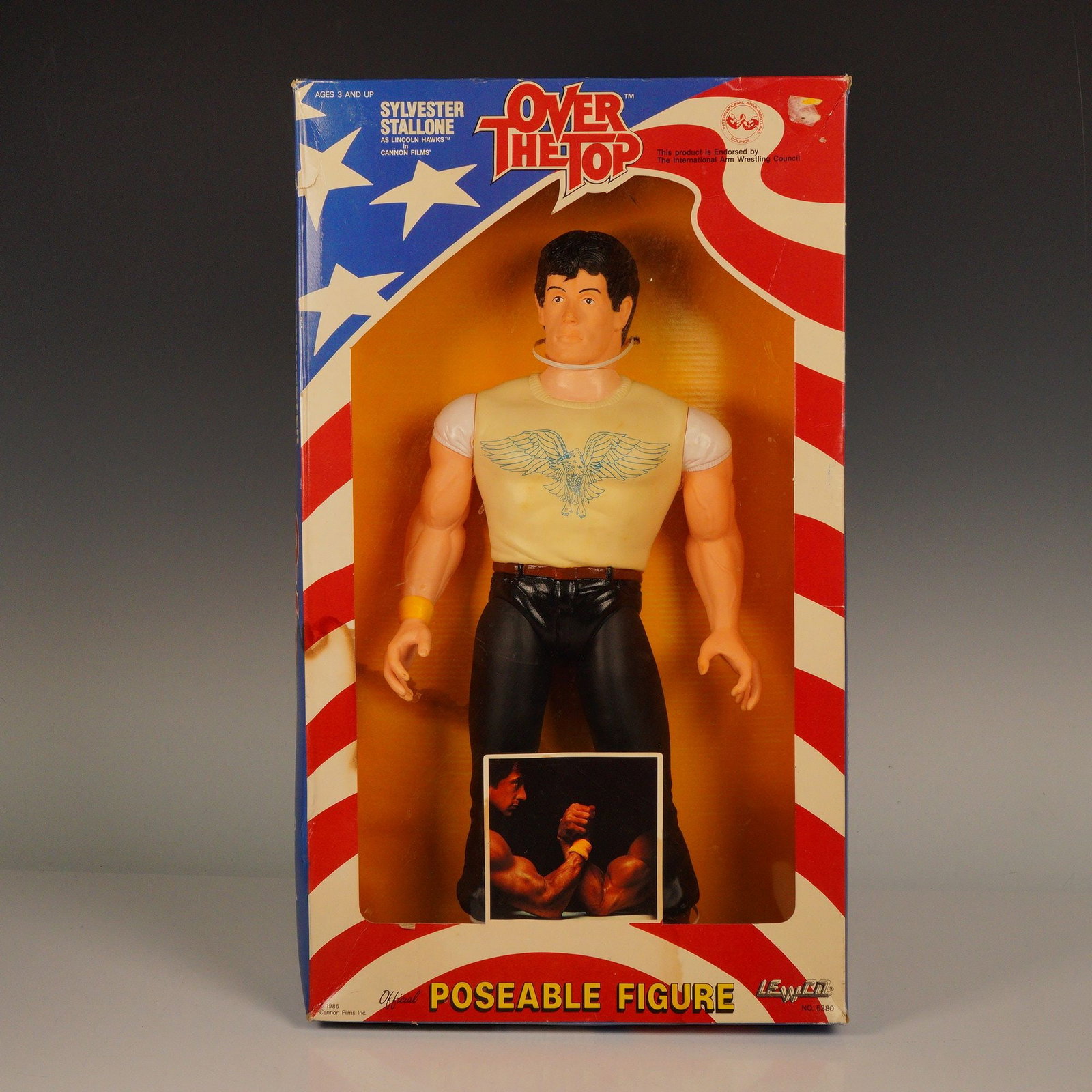 Sylvester Stallone Over The Top Poseable Figure: This Sylvester Stallone poseable action figure from the 1987 movie Over The Top captures the iconic arm wrestler in action. Produced by LJN Toys, the figure features Stallone in his trademark pose, re