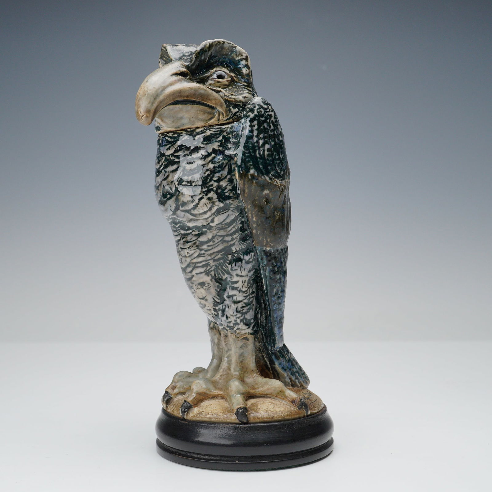 Martin Brothers Stoneware Grotesque Wally Bird Tobacco Jar: A stoneware tobacco jar modeled in the form of a bird with a large beak and detailed feather texture, featuring a detachable head that serves as the lid. The surface is finished in mottled tones of gr