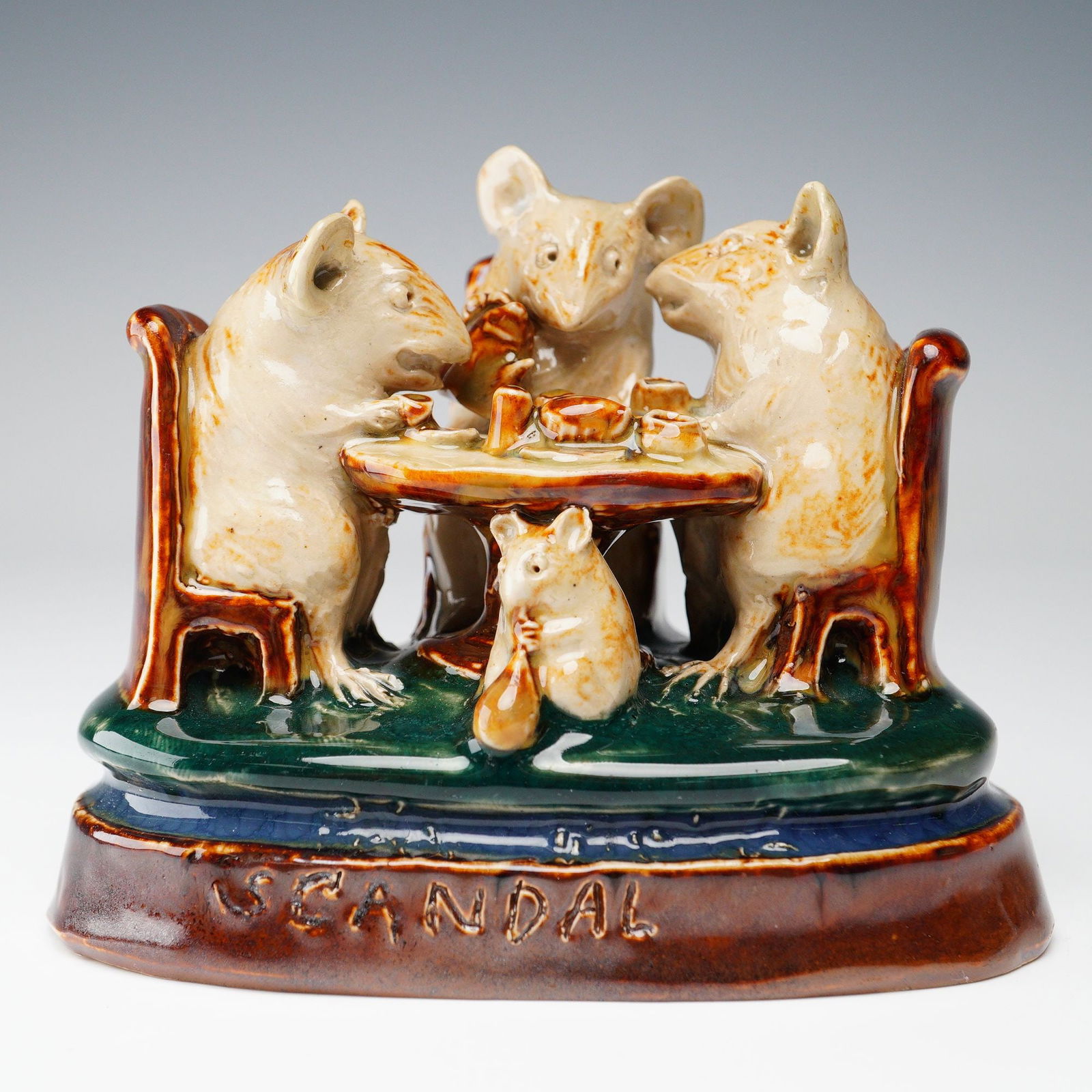 Doulton Lambeth by George Tinworth Stoneware Figurine, Teatime Scandal: Whimsical stoneware figure group modeled by George Tinworth. It depicts an anthropomorphic tableau of four mice gathered around a tea table in animated discussion while a smaller onlooker clutches a s
