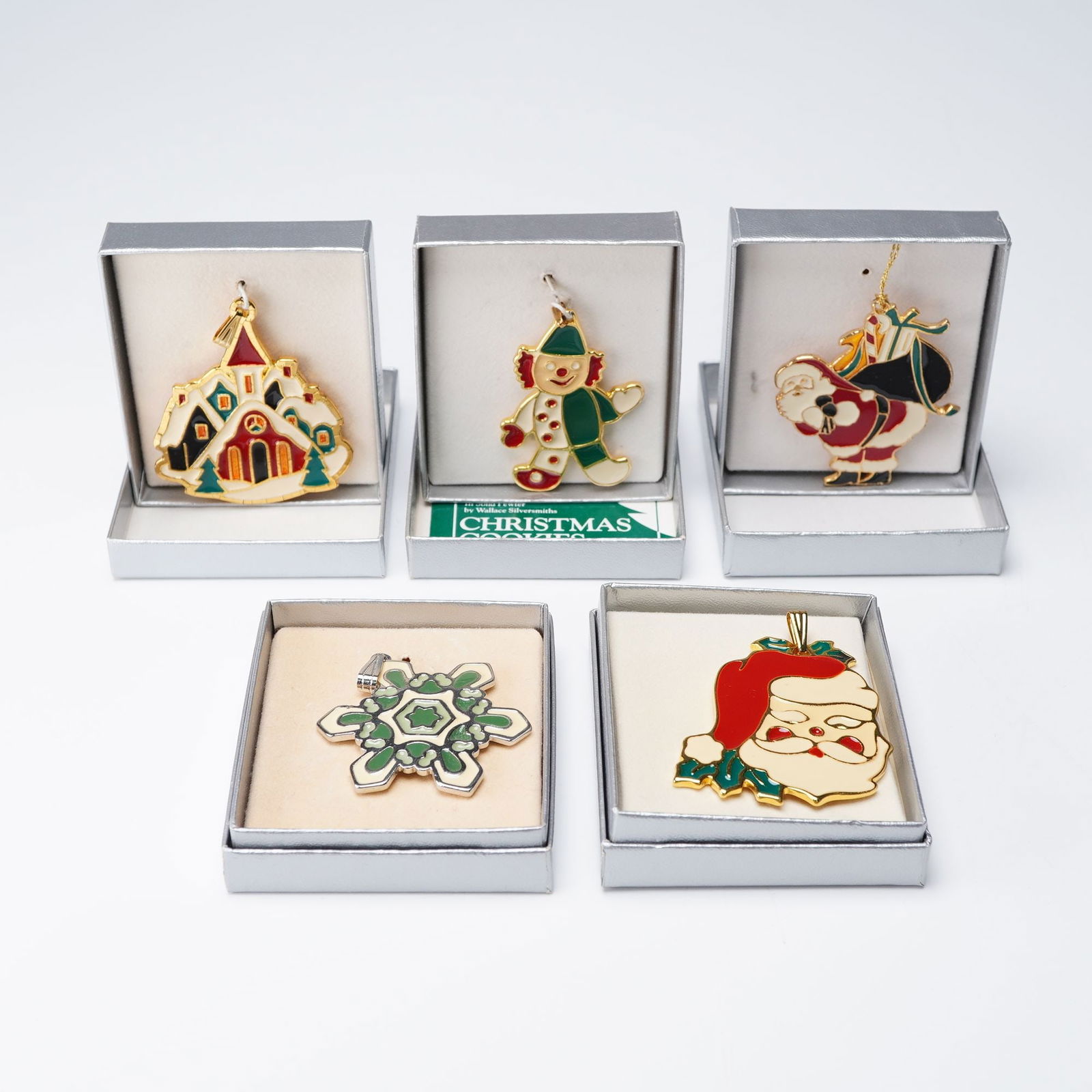 5pc Wallace Silversmiths Enameled Christmas Pendants: A distinguished collection of five hand enameled charms in various festive colors. Included is a Snowflake, Santa Head, Clown, Christmas Village, and Santa with Bag of Toys. These adorable charms can