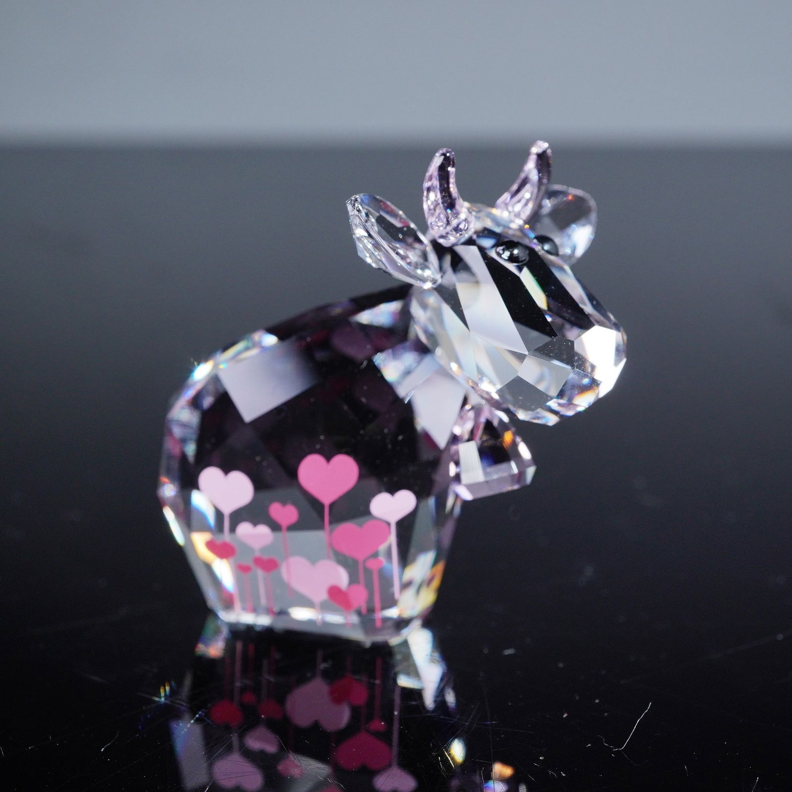 Swarovski Lovlots Love Mo Limited Edition 2015 Figurine: A Swarovski Lovlots 'Love Mo' Limited Edition 2015 figurine. Crafted from clear faceted crystal, depicting a cow or bull. The horns and ears are rendered in slightly pink tinted crystal. The body is a