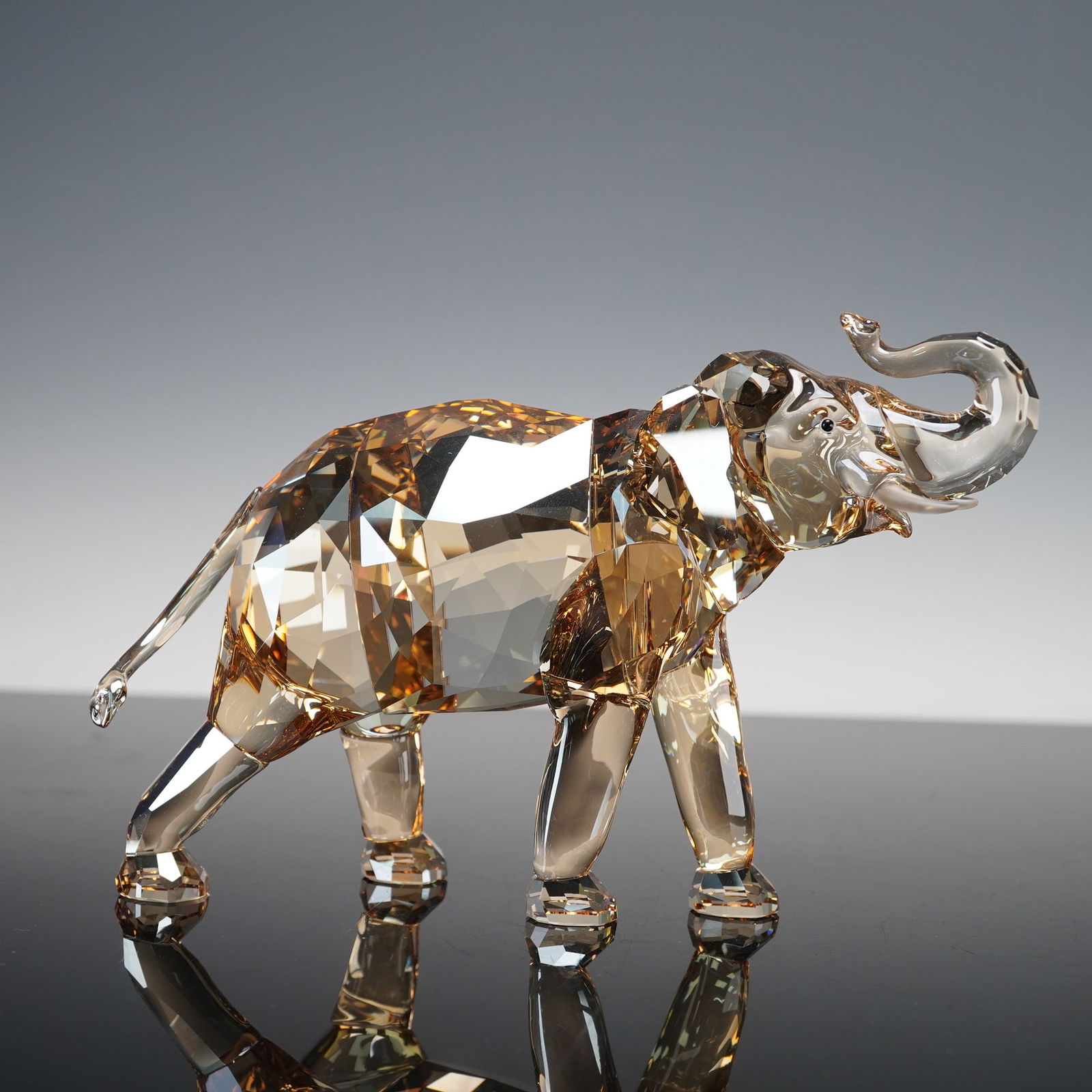 Swarovski Annual Edition Crystal Figurine, Cinta The Elephant: An exquisite crystal figurine made for the Swarovski Crystal Society. Expertly designed with precision-cut facets in warm golden-brown tones, the piece captures the grandeur and grace of the animal wi