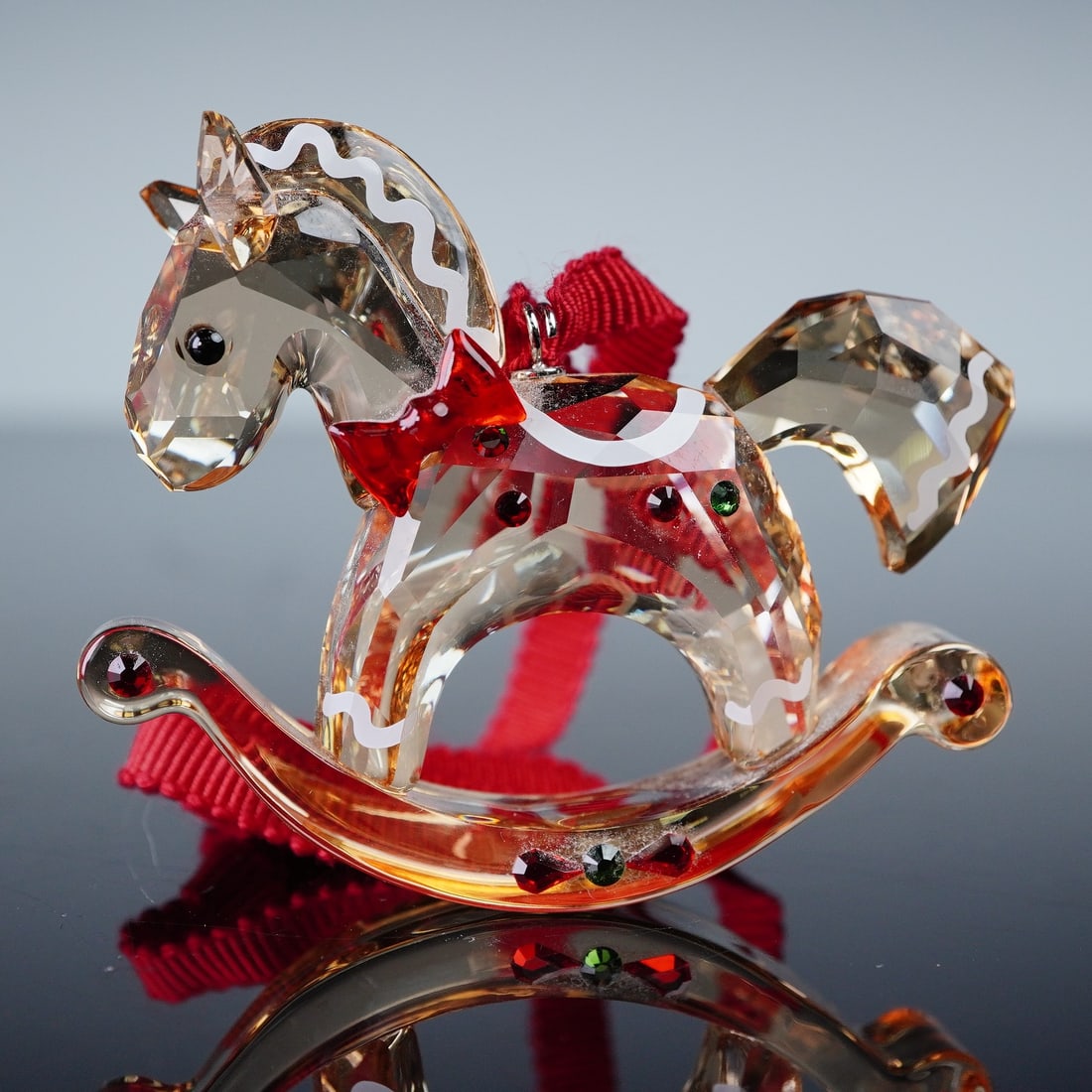 Swarovski Christmas Ornament, Gingerbread Rocking Horse: Swarovski crystal Christmas ornament Gingerbread Rocking Horse, item 5627608, designed with faceted golden crystal body, red bow, green and red crystal accents, and painted white trim. Retains origina