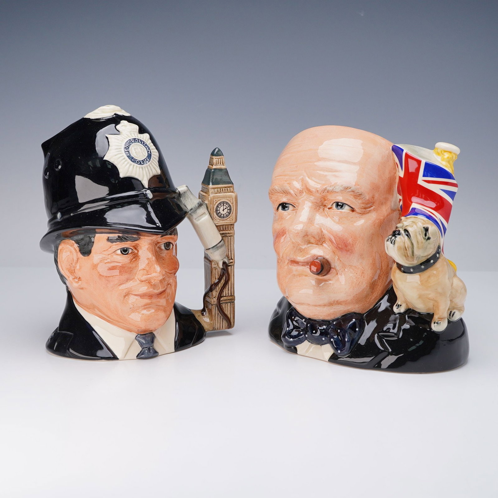 2pc Royal Doulton Character Jugs, Winston Churchill and The London Bobby: Pair of Royal Doulton large character jugs including Winston Churchill D6907 and The London Bobby D6744. Both hand made and hand decorated, modeled by Stanley James Taylor. The Churchill jug was issue