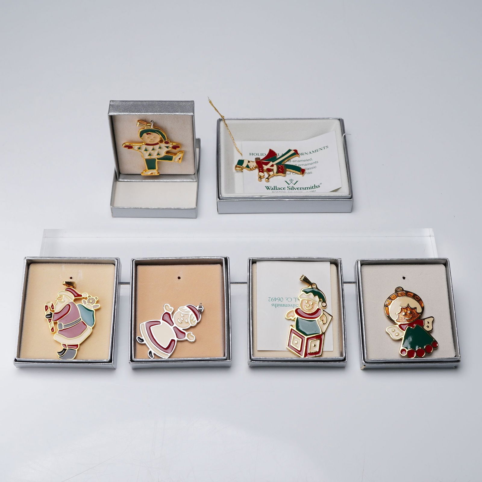 6pc Wallace Silversmiths Enameled Christmas Pendants: A delightful ensemble of six silver toned and gold plated charms, each designed in colorful enameled. The collection includes characters such as Santa, with Bags of Toy Mrs. Claus, Boy Skater, Angel,