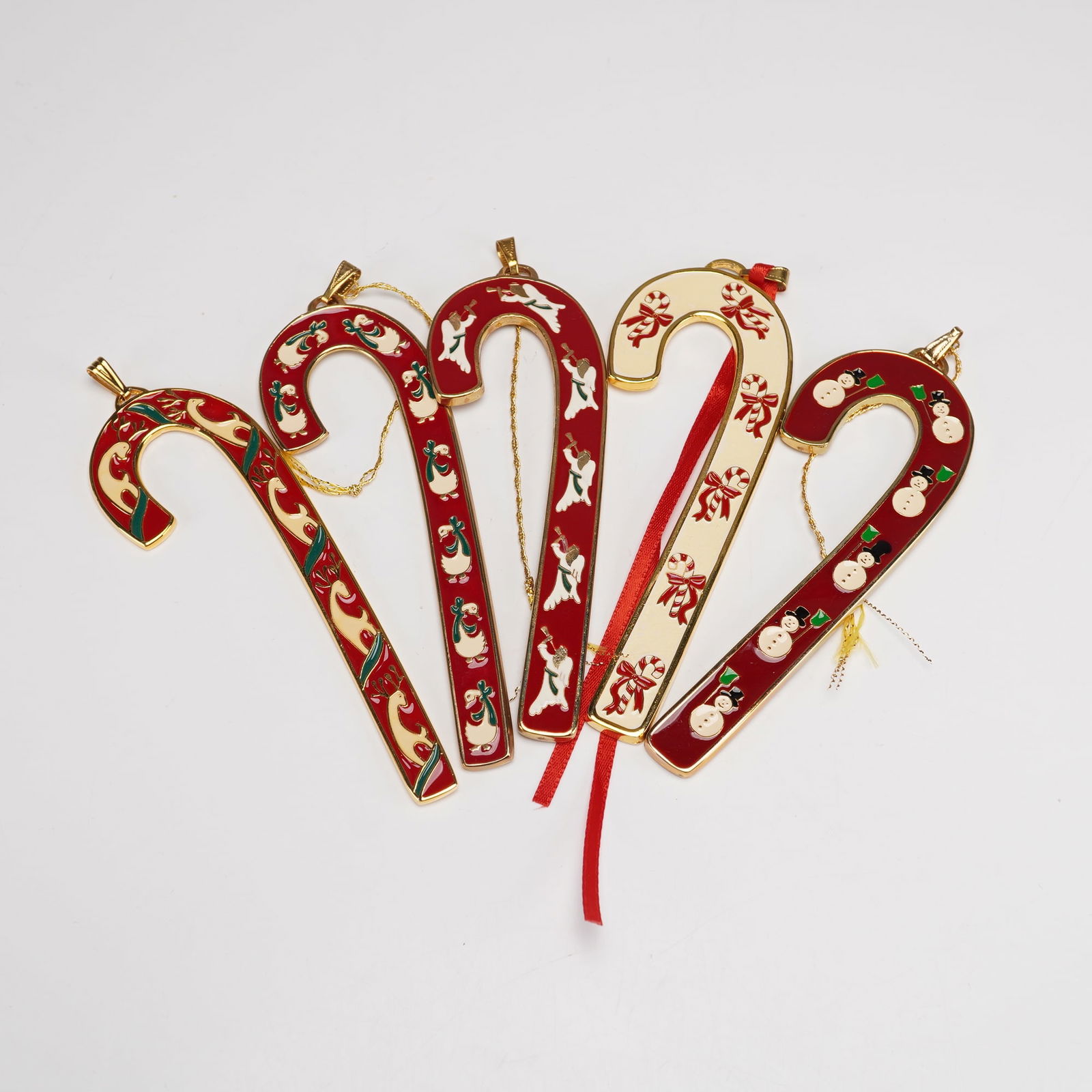 5pc Wallace Silversmiths Annual Candy Cane Ornaments: This festive five piece collection features Wallace Silversmiths Annual Candy Cane ornaments from 1990 through 1994. Four display bold red enamel backgrounds and one features a soft white finish, each