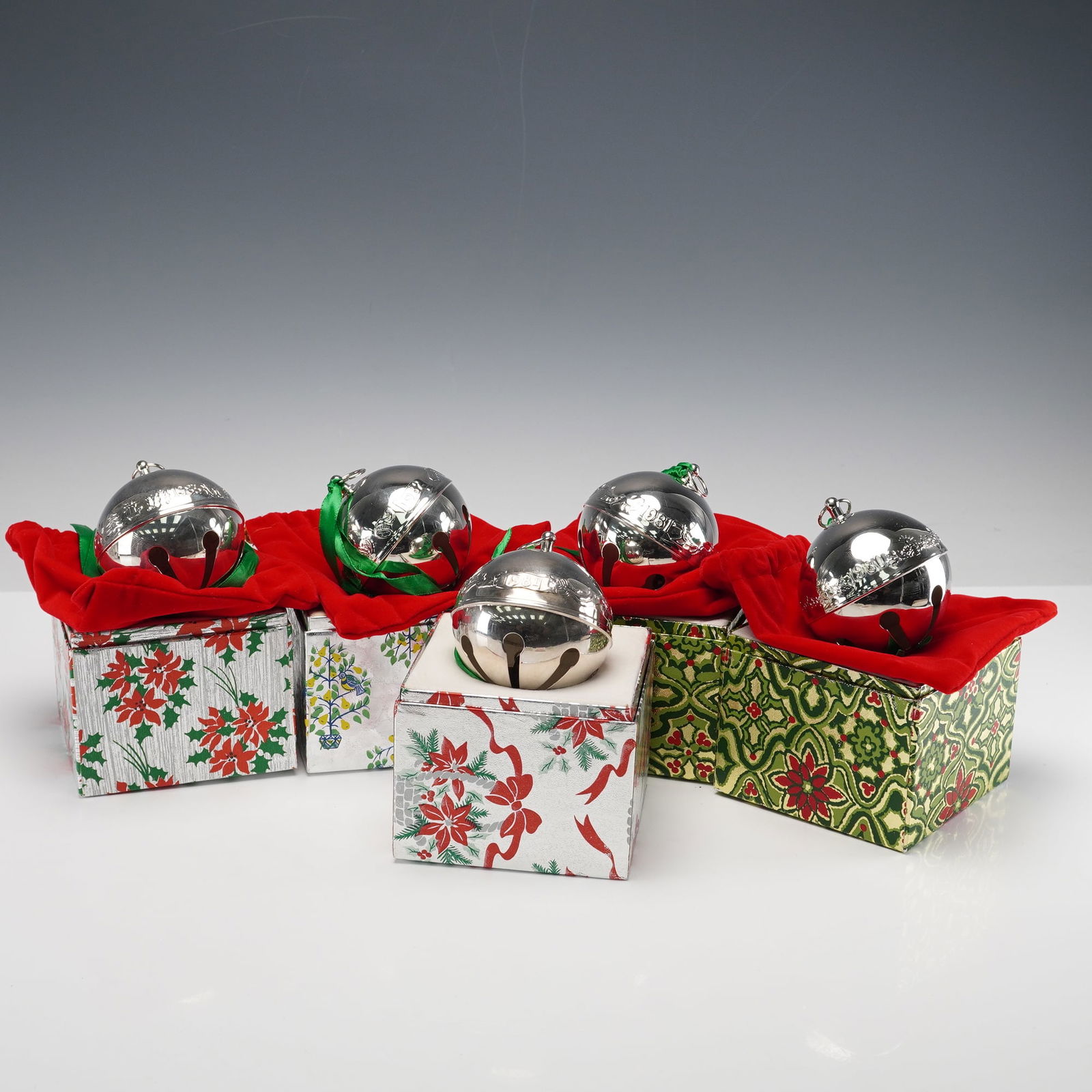 5pc Wallace Silversmiths Annual Sleigh Christmas Bell Ornaments: A collection of five polished silverplate sleigh bells by Wallace Silversmiths, each engraved with its respective production year and featuring the maker's hallmark underside. These collectible orname