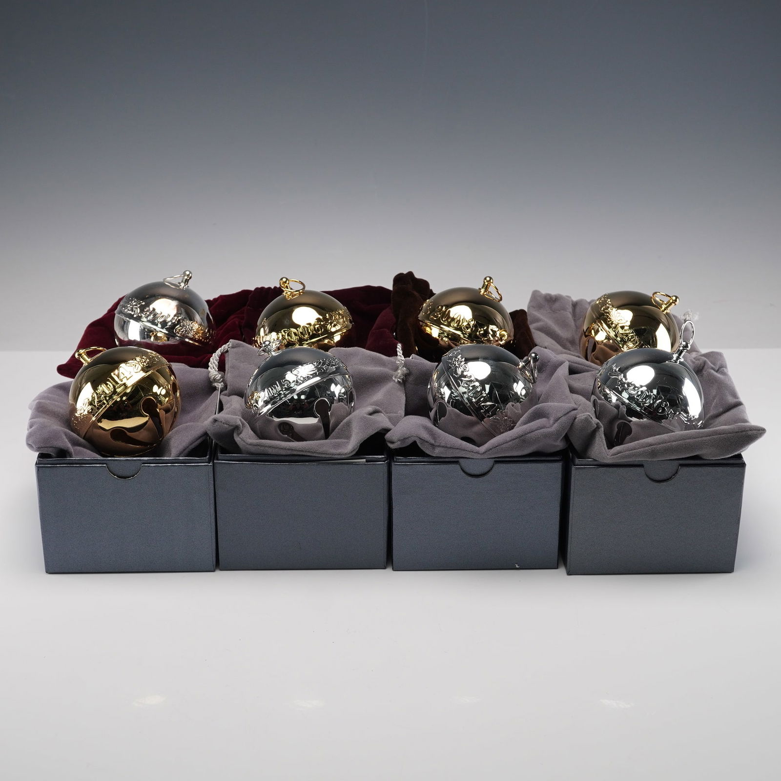 8pc Wallace Silversmiths Annual Sleigh Christmas Bell Ornaments: Collection of eight Wallace Silversmiths Annual Sleigh Bells, including four gold-plated and four silver-plated examples. Each ornament features raised decorative motifs and is presented in its origin