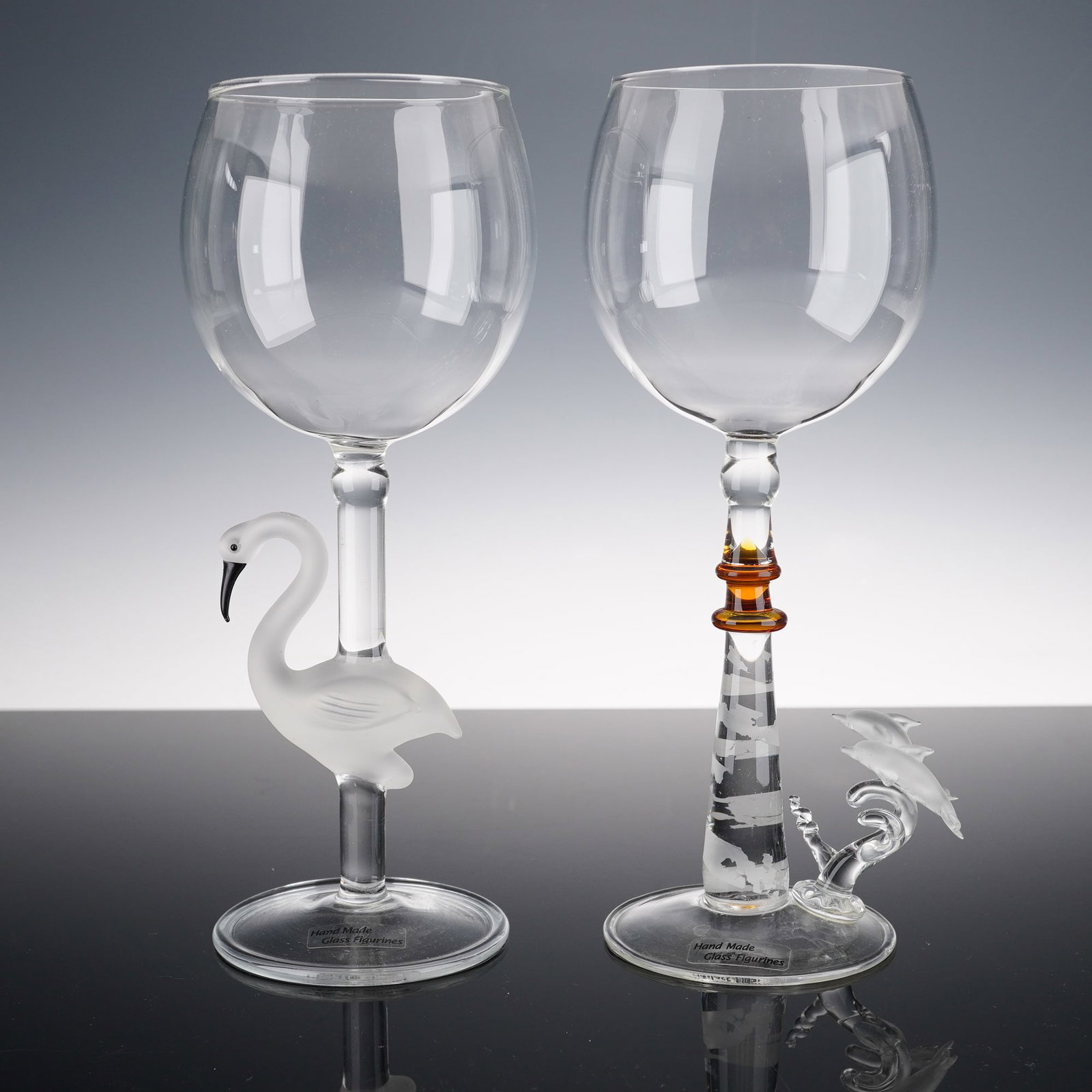 2pc Yurana Art Glass Figural Wine Glasses, Flamingo and Dolphin Adventure: This elegant two piece set of Yurana Art Glass figural wine glasses highlights the beauty of handcrafted glasswork. One glass features a frosted clear flamingo with graceful curves and a slender neck,