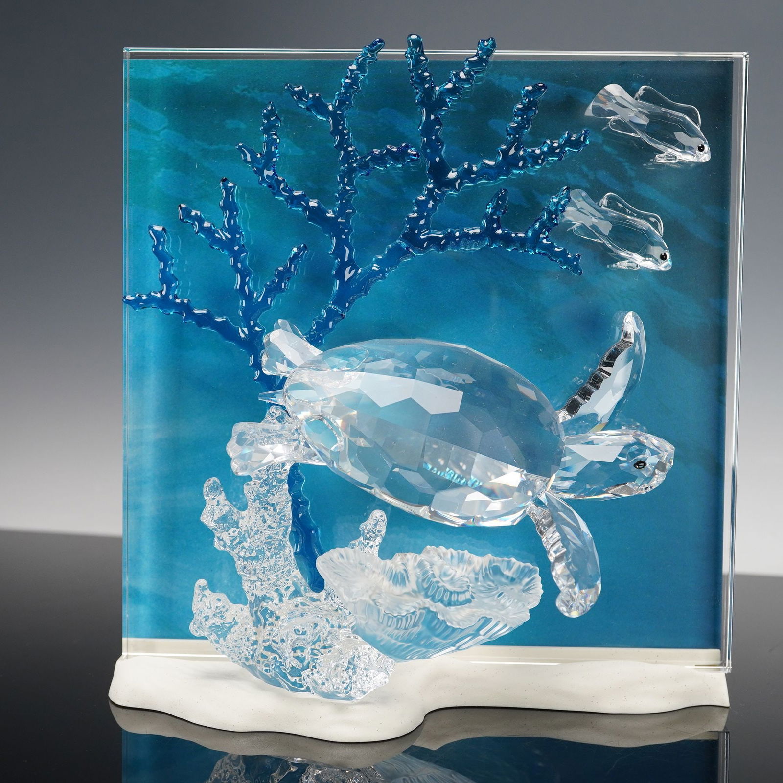 Swarovski Wonders of The Sea Crystal Figurine, Eternity: A striking crystal composition depicting a graceful sea turtle gliding through an underwater world of coral and fish. This masterfully crafted glass sculpture features a faceted turtle rendered in cle