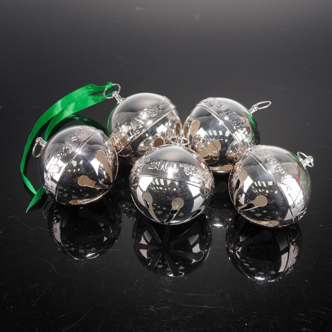 5pc Wallace Silversmith Christmas Bells: A charming collection of five silver-plated Christmas bell ornaments, each featuring a polished reflective surface and engraved decorative band. The assortment includes annual editions dated, each sus