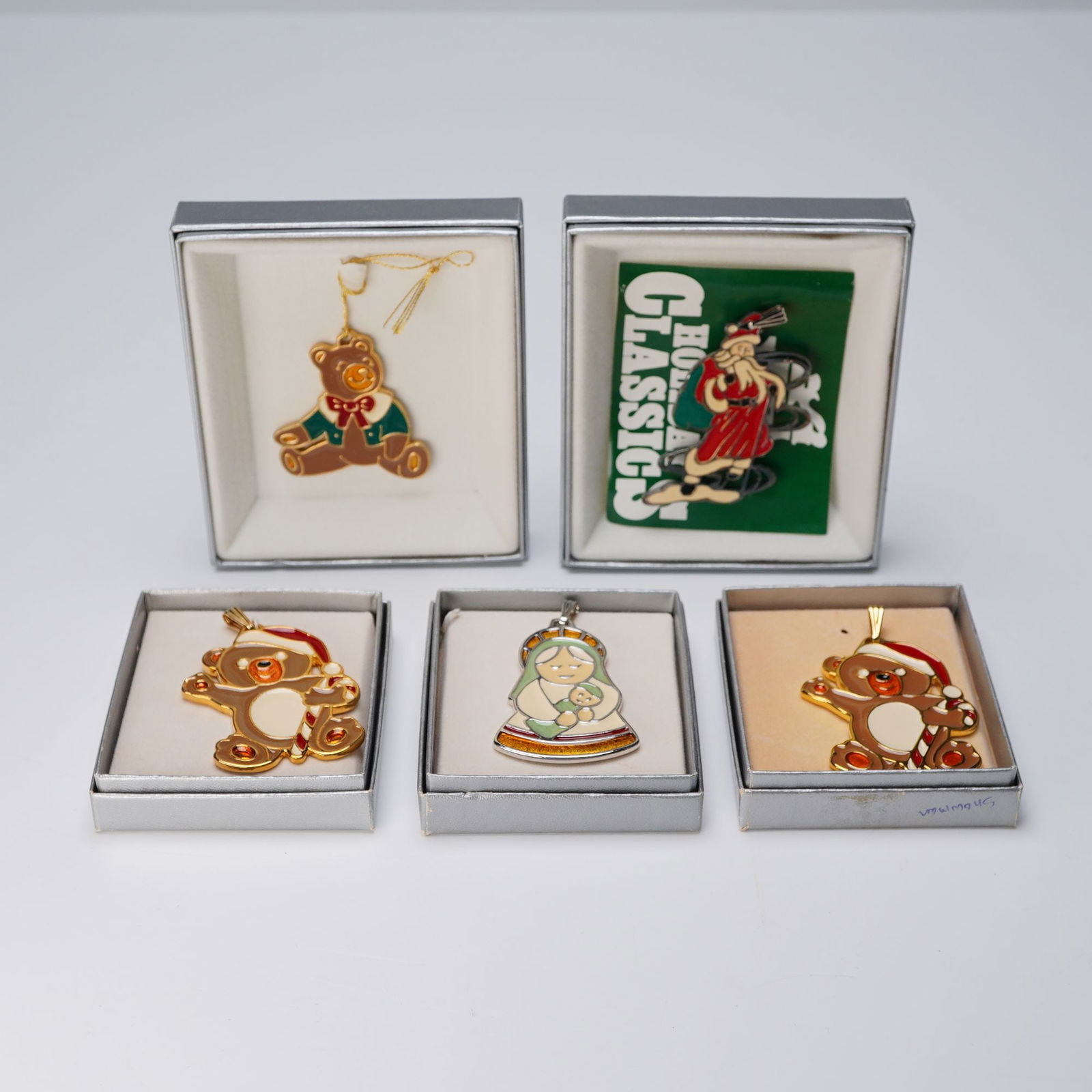 5pc Wallace Silversmiths Enameled Christmas Pendants: A refined assembly of five silver toned and gold plate ornaments. Each meticulously adorned with rich enamel coloration and crafted with thematic reverence. Included is two Teddy's, Santa, Mother and