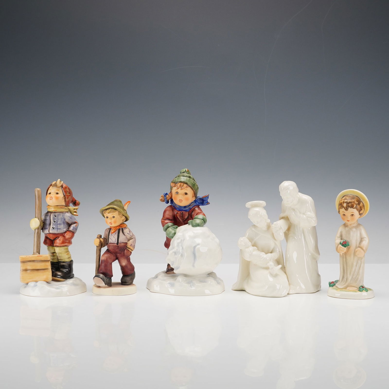 5pc Goebel Hummel Porcelain Holiday and Winter Figurines: Charming collection of five Goebel Hummel porcelain figurines, all marked Goebel W. Germany. The group includes Nativity (Madonna and Child with Saint Joseph), Angel, First Snow, Let It Snow, and Gran
