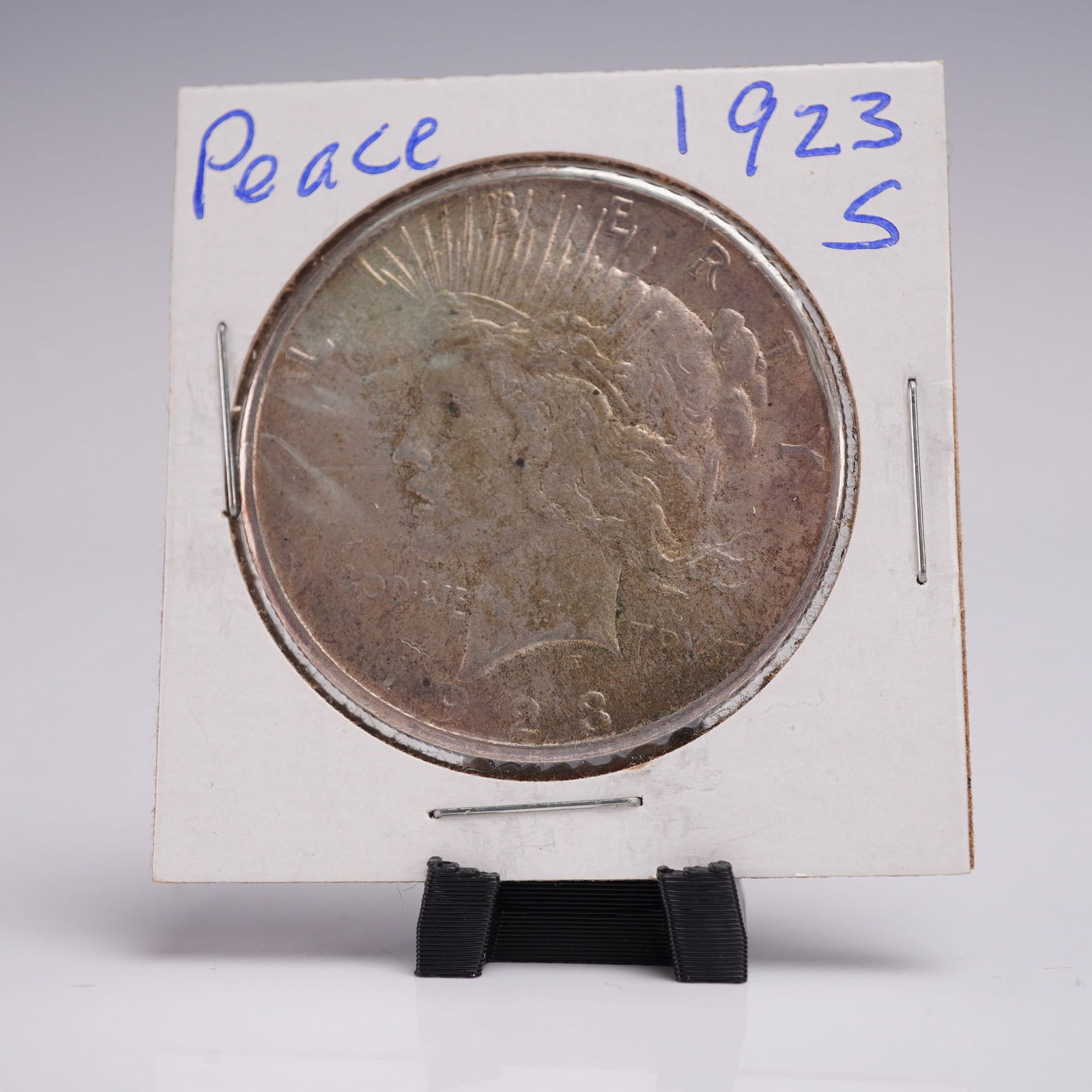 1923-S Peace Dollar Silver One Dollar Coin: Produced at the San Francisco Mint, this 1923-S Peace Silver Dollar is struck in .999 silver. The obverse features the left facing profile of Liberty adorned with a radiant diadem, framed by the inscr
