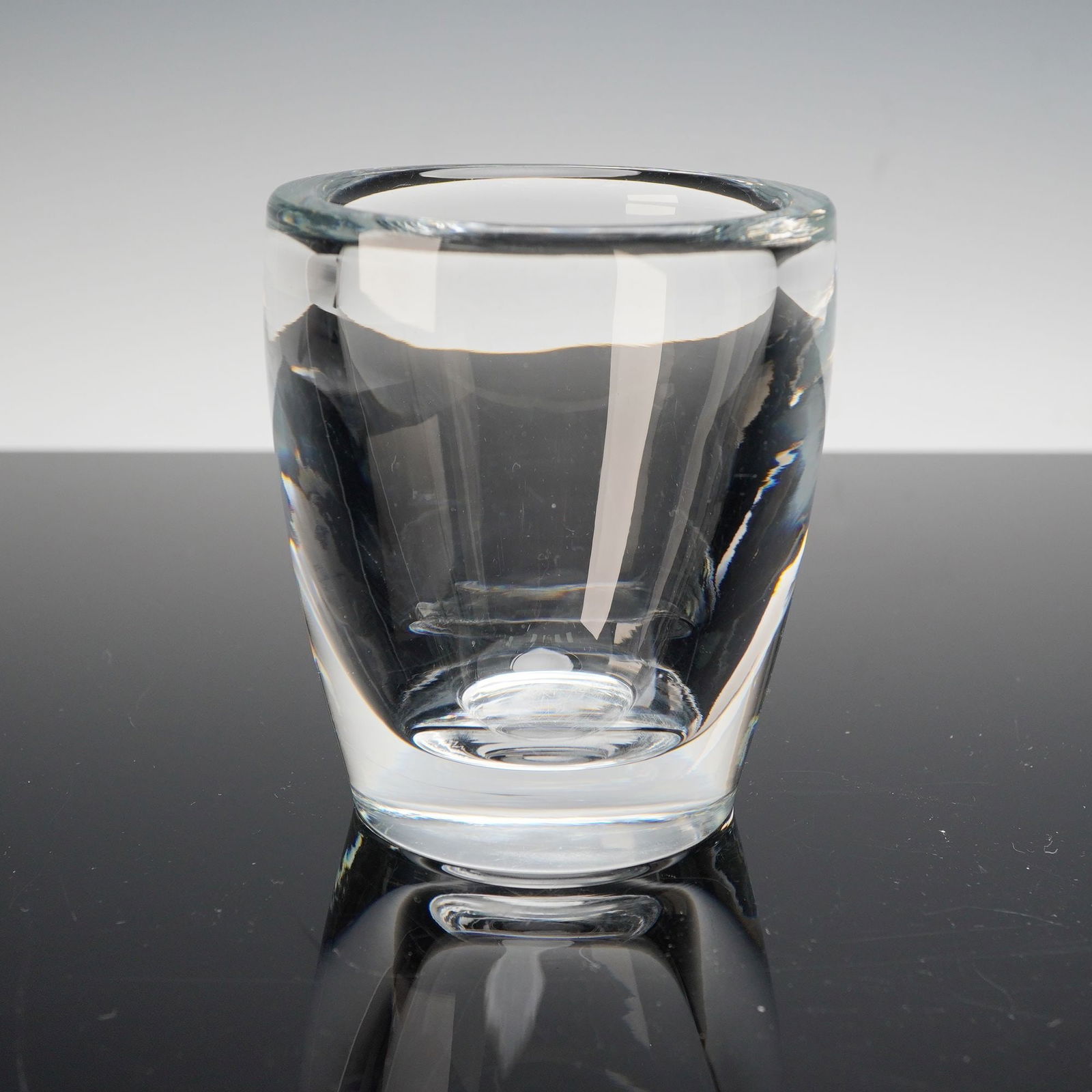 Steuben Crystal Short Vase: This finely crafted Steuben crystal vase showcases the company's signature clarity and precision. Standing approximately 4 inches tall, the vase features a clean, modern form with thick, sculpted wall
