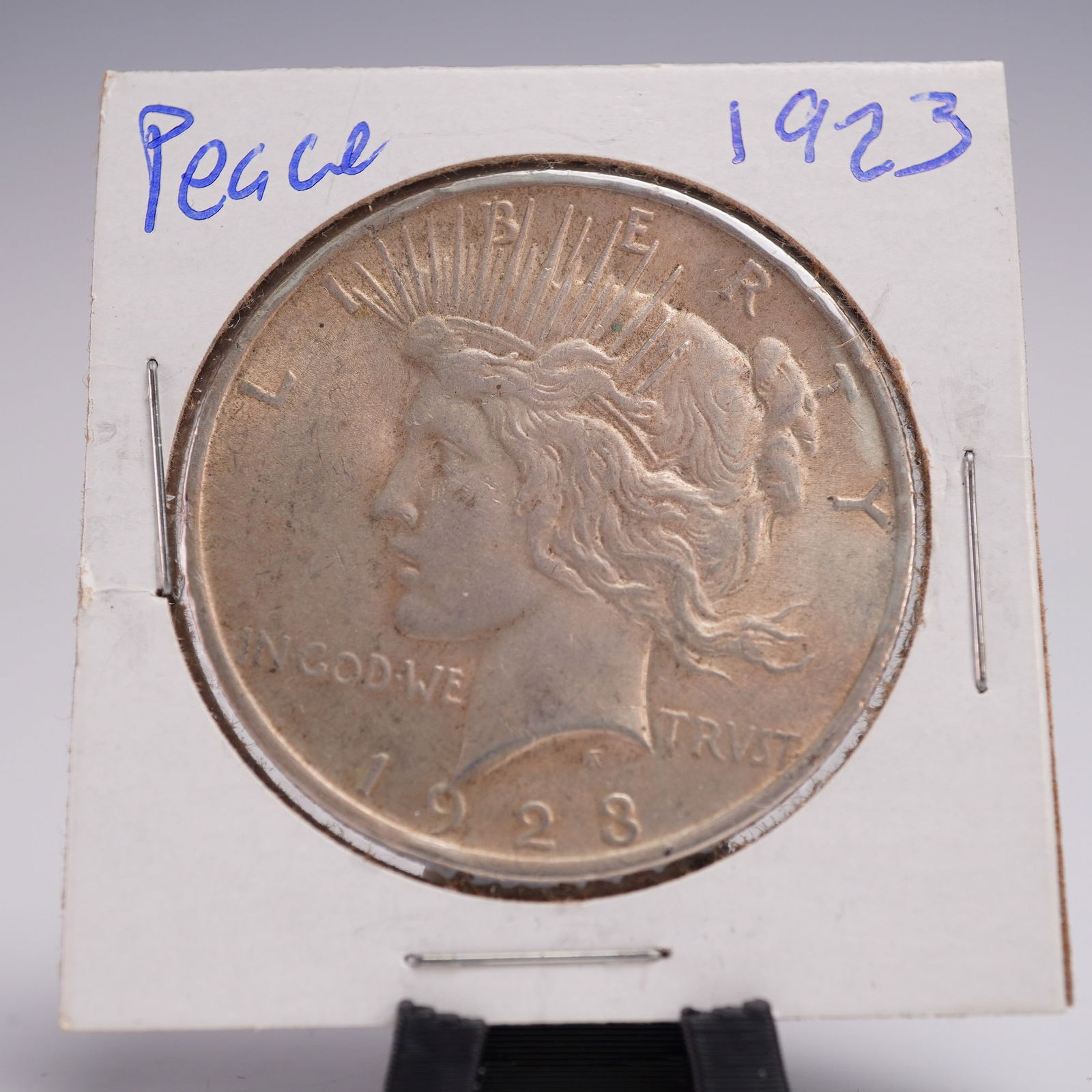 1923 Peace Dollar Silver One Dollar Coin: This 1923 Peace Dollar composed of 90% silver and 10% copper. The obverse elegantly showcasing left-facing effigy of Lady Liberty adorned with a radiant diadem symbolic of enlightenment and post-war h