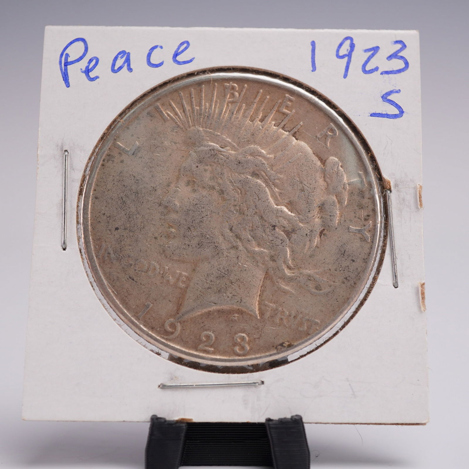 1923-S Peace Dollar Silver One Dollar Coin: Struck at the San Francisco Mint, this 1923-S Peace Dollar composed of .999 silver. The face of the coin bears the left-facing profile of Lady Liberty crowned with radiant spikes, symbolizing peace fo