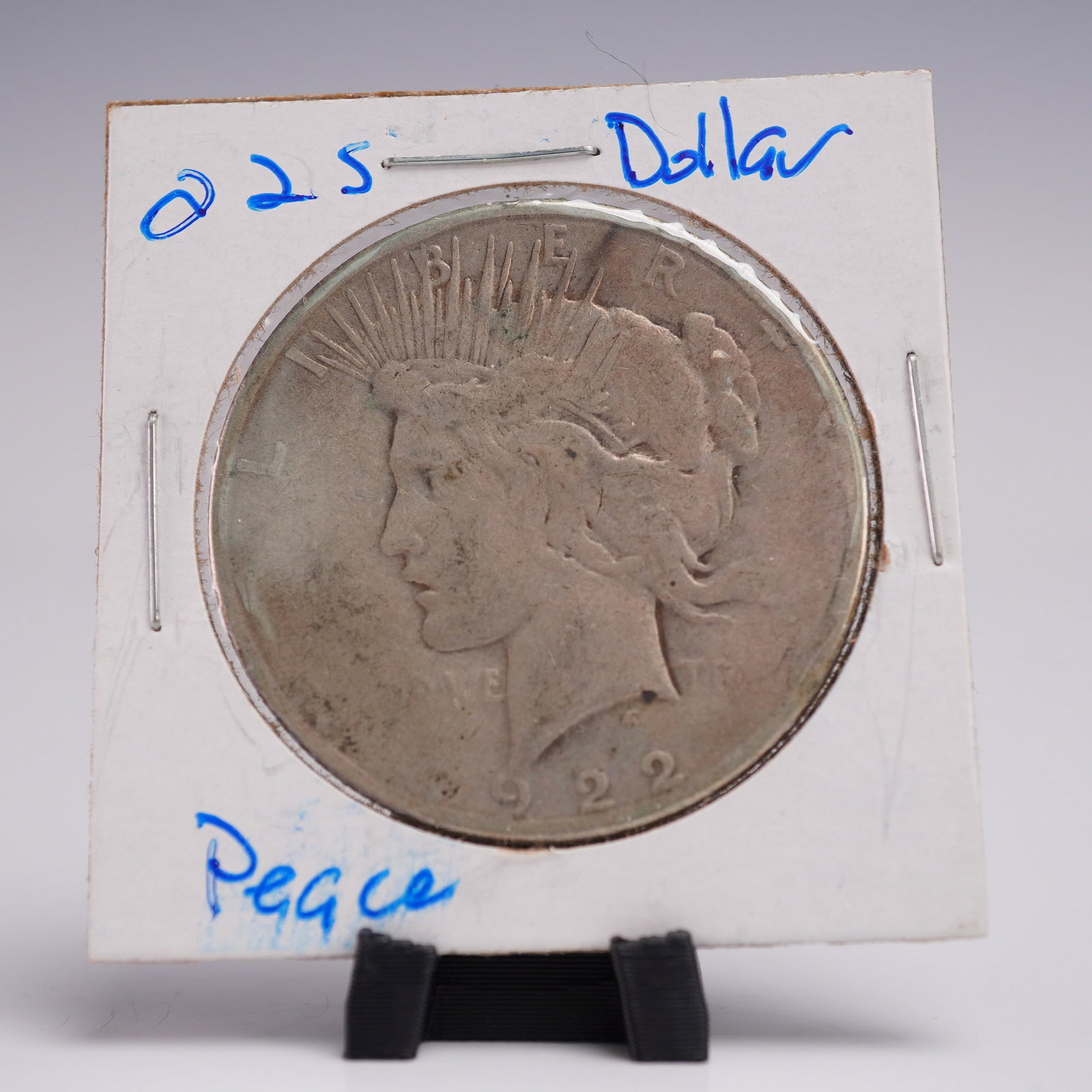1922-S Peace Dollar Silver One Dollar Coin: Struck at the San Francisco Mint, this 1922-S Peace Dollar composed of .999 fine silver. Features the stately profile of Lady Liberty facing left, her hair flowing beneath a radiant diadem that symbol