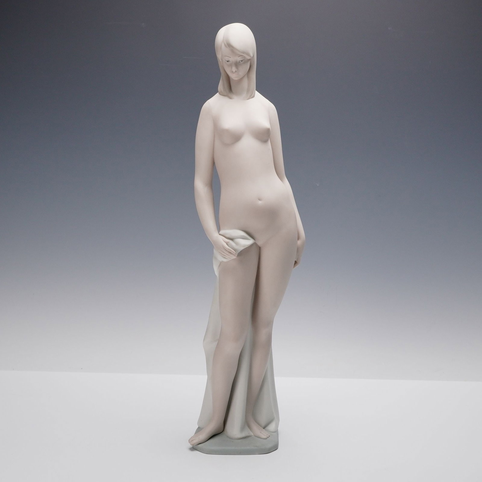 Lladro Matte Porcelain Sculpture, Nude 01014511: Lladro matte porcelain sculpture titled Nude (01014511), designed by Juan Huerta. This refined and serene depiction of a standing female nude showcases Lladro's mastery of form and emotion through min