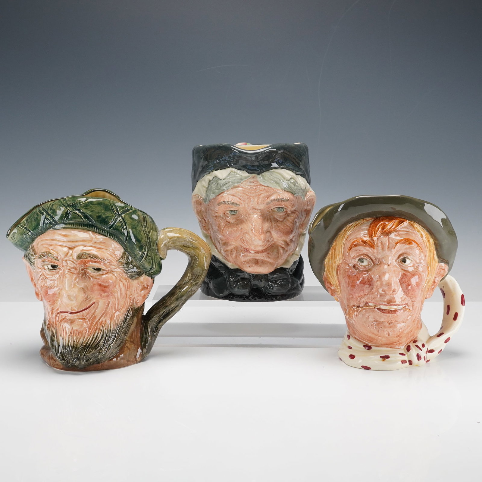 3pc Royal Doulton Large Character Jugs- D6288, D5521 & D5823: Royal Doulton large character jugs designed by Harry Fenton, including Jarge D6288, depicting a cheerful farmer wearing a green cap; Granny D5521, modeled as an elderly woman in a dark bonnet with a k