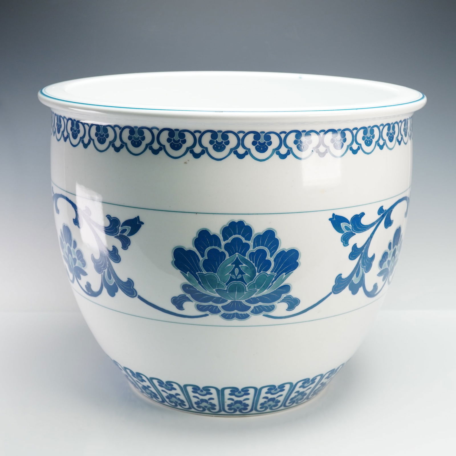 Chinese Blue and White Porcelain Jardiniere: A large and finely decorated Chinese porcelain jardiniere featuring underglaze blue lotus blossom and scrolling foliate motifs in traditional style. The vessel presents a broad flared rim and continuo