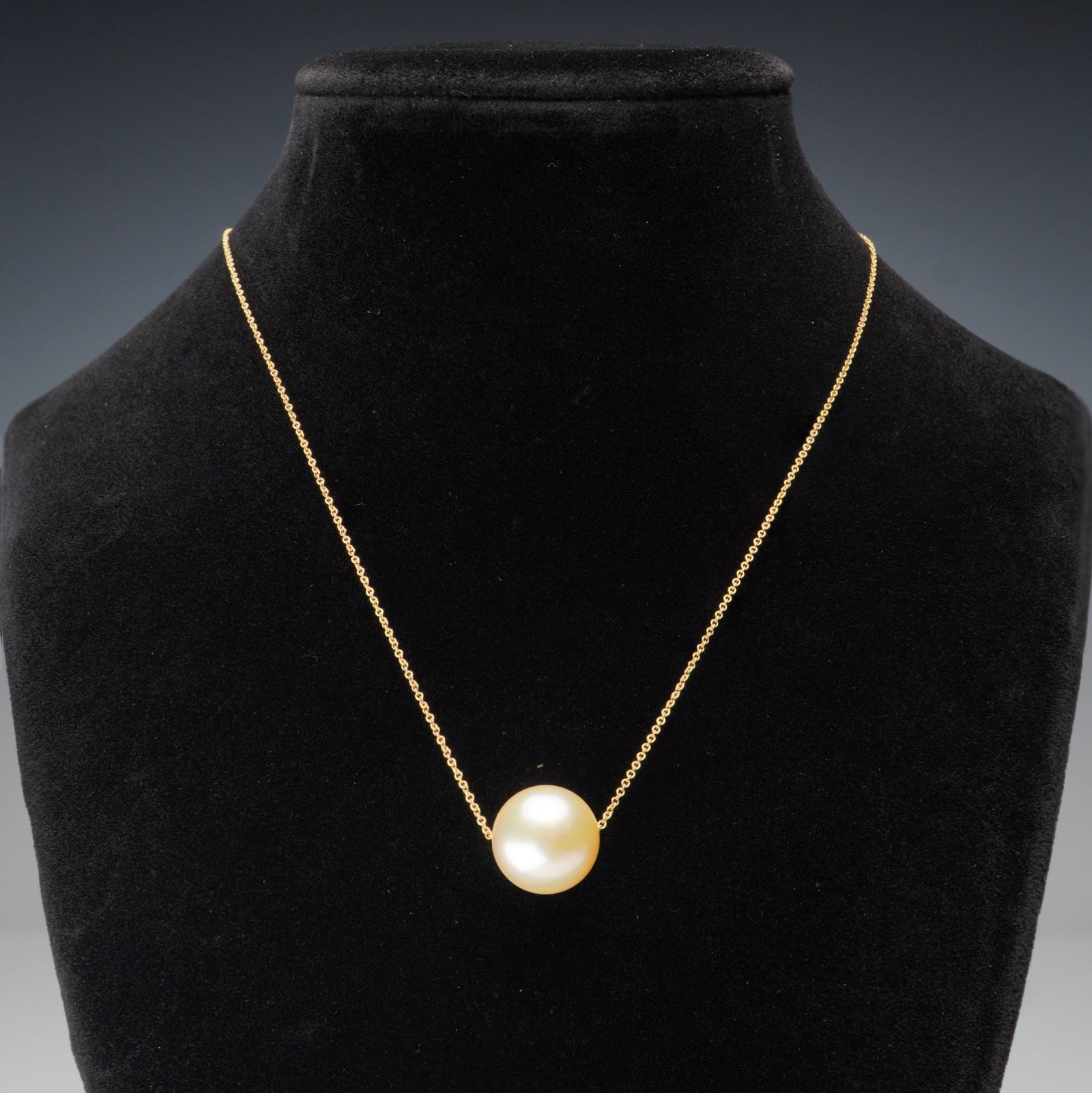 18K Yellow Gold South Sea Pearl Necklace: A refined 18K yellow gold necklace showcasing a luminous South Sea pearl that glides freely along the chain. The pearl displays a soft golden hue with high luster and smooth surface, offering understa