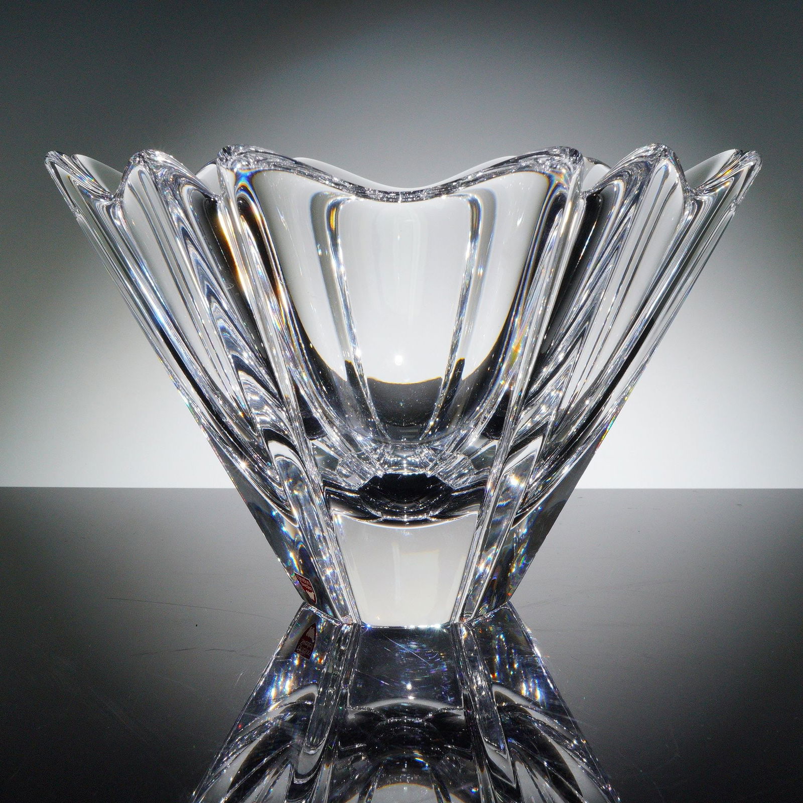 Orrefors Crystal Tulip Bowl: The bowl features gracefully flared petal-like panels that create a floral silhouette, expertly cut and polished to showcase brilliant refraction and clarity. Retains the original Orrefors red foil la