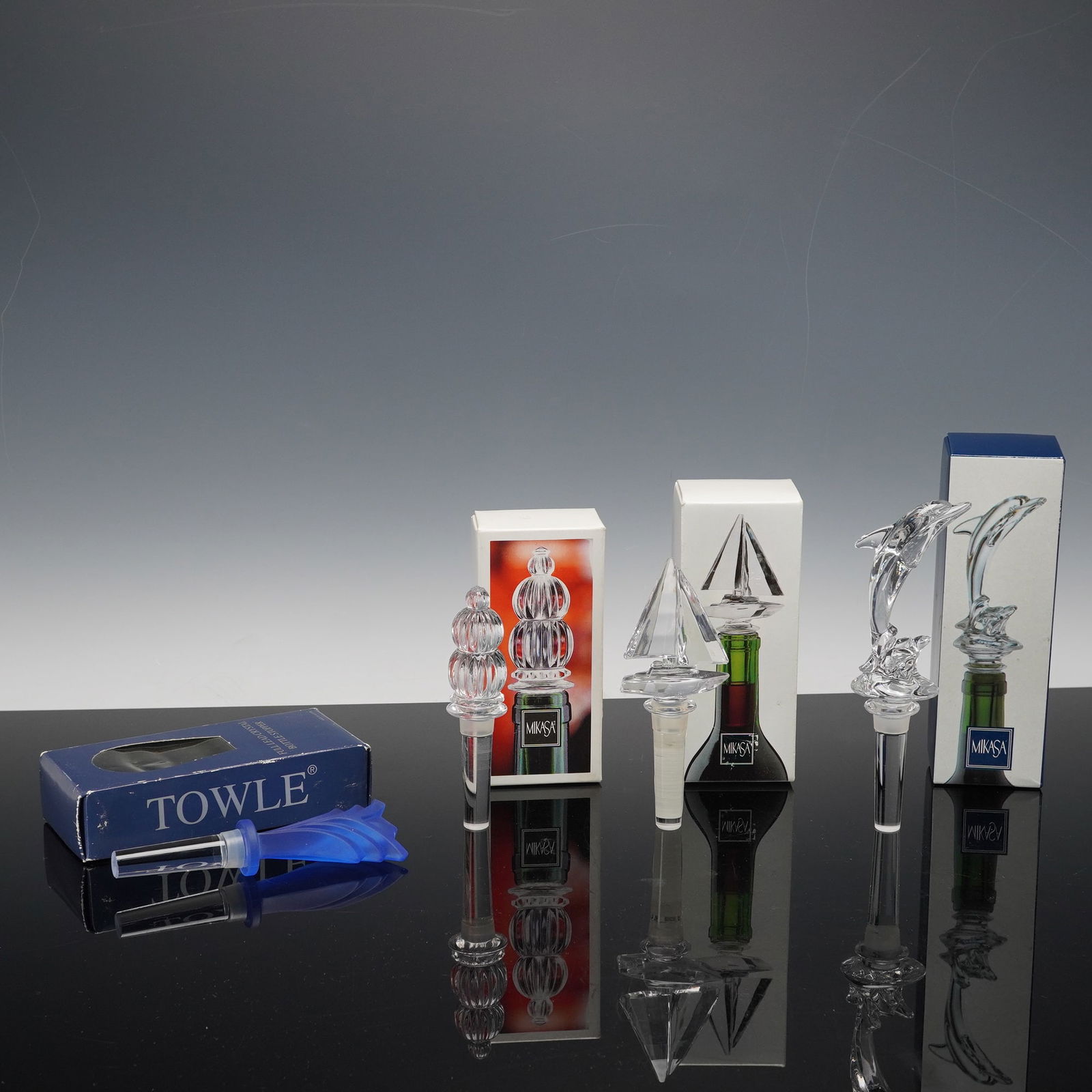 4pc Mikasa and Worcester Crystal Bottle Stoppers: Collection of four crystal bottle stoppers by Mikasa and Towle. The lot includes three clear Mikasa design, Dolphin, Regatta Sailboat, and Monterey, each crafted in brilliant full-lead crystal and acc