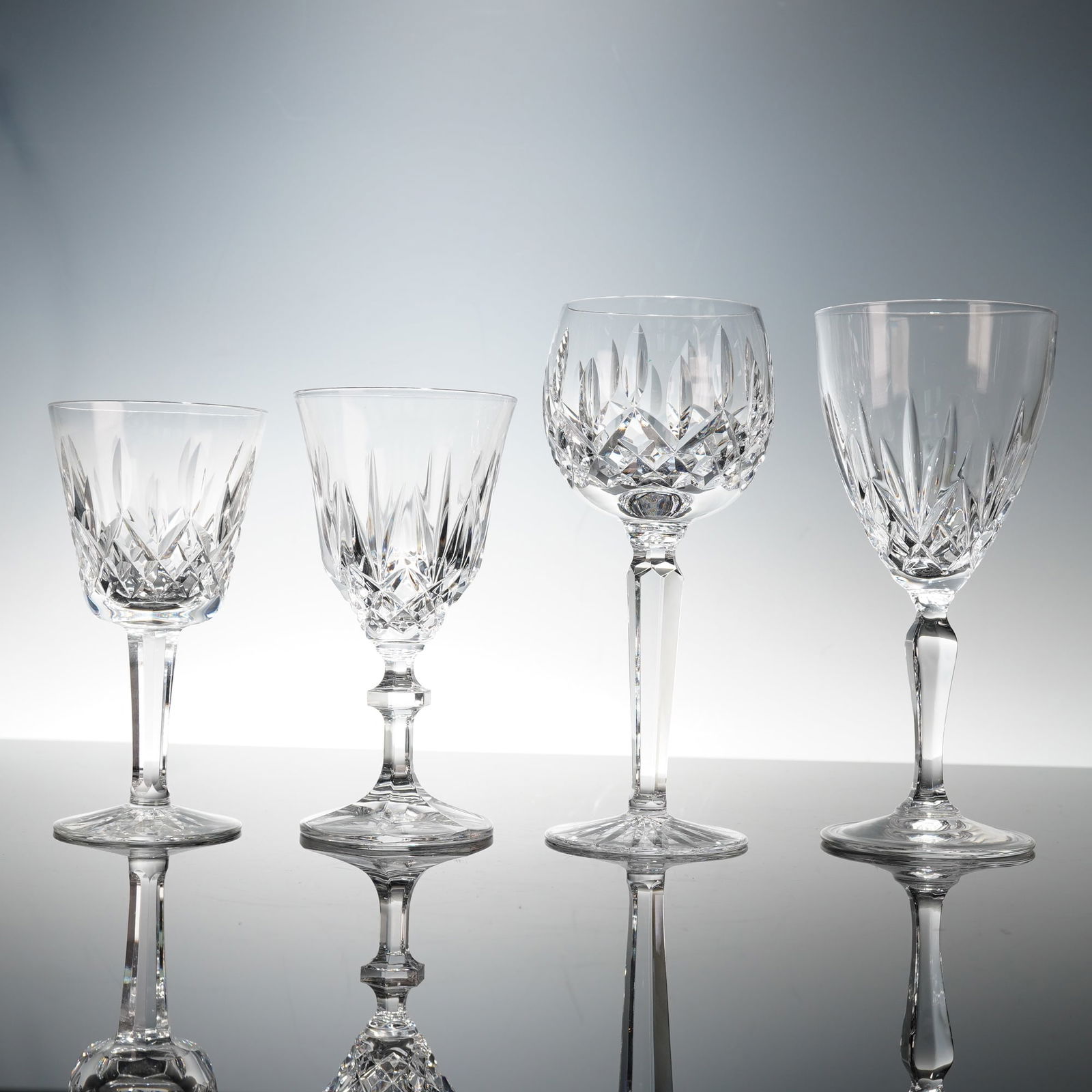 4pc Waterford Crystal Wine and Water Glasses: A group of four crystal stem glasses comprising a Waterford Lismore white wine glass and red wine goblet, each finely cut with the classic diamond and wedge design and etched Waterford mark, together
