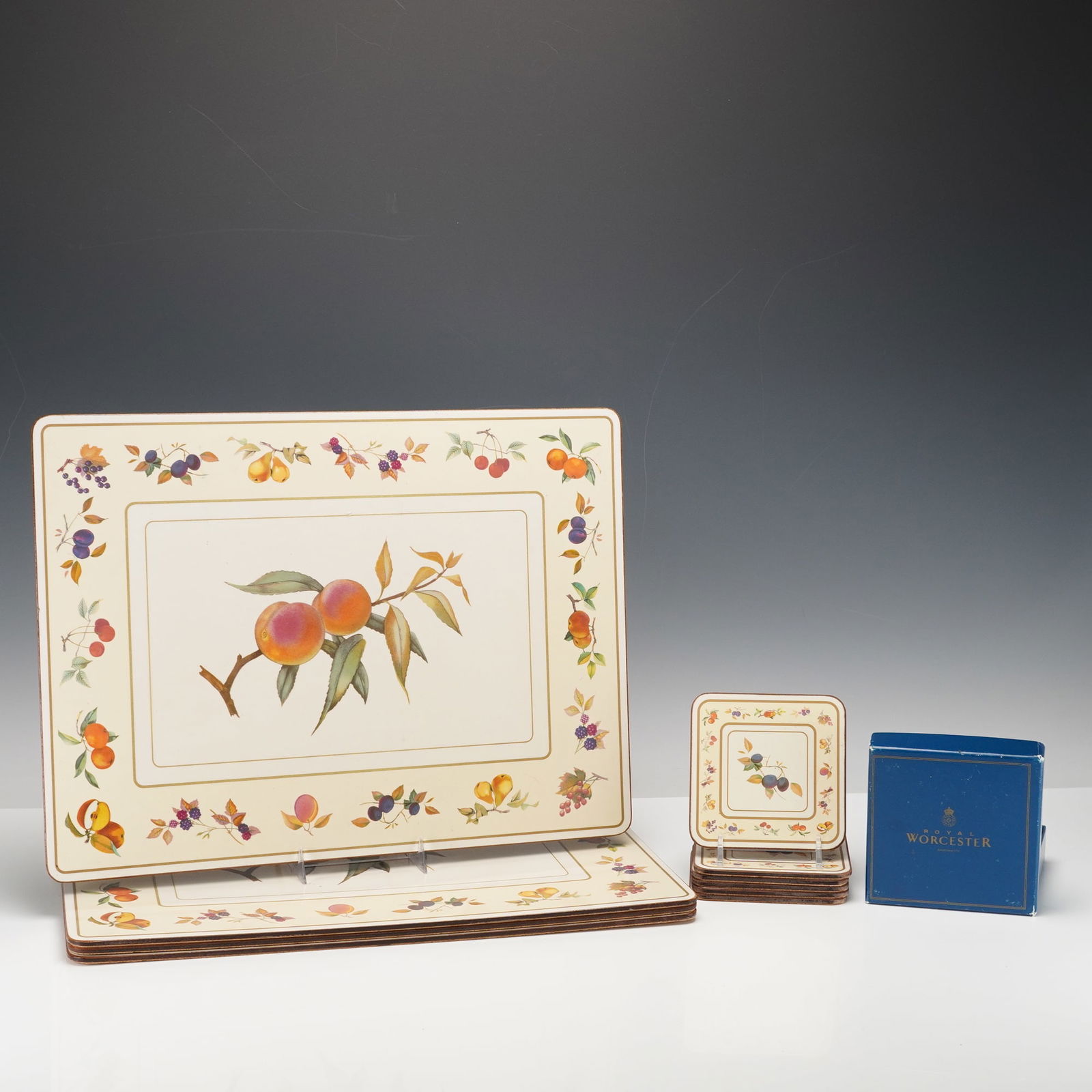 10pc Royal Worcester Coasters and Placemats Set, Evesham Pattern: This 10-piece Worcester set includes four placemats and six coasters, all featuring the Evesham fruit and floral pattern. The placemats highlight a central peach design surrounded by colorful fruits a