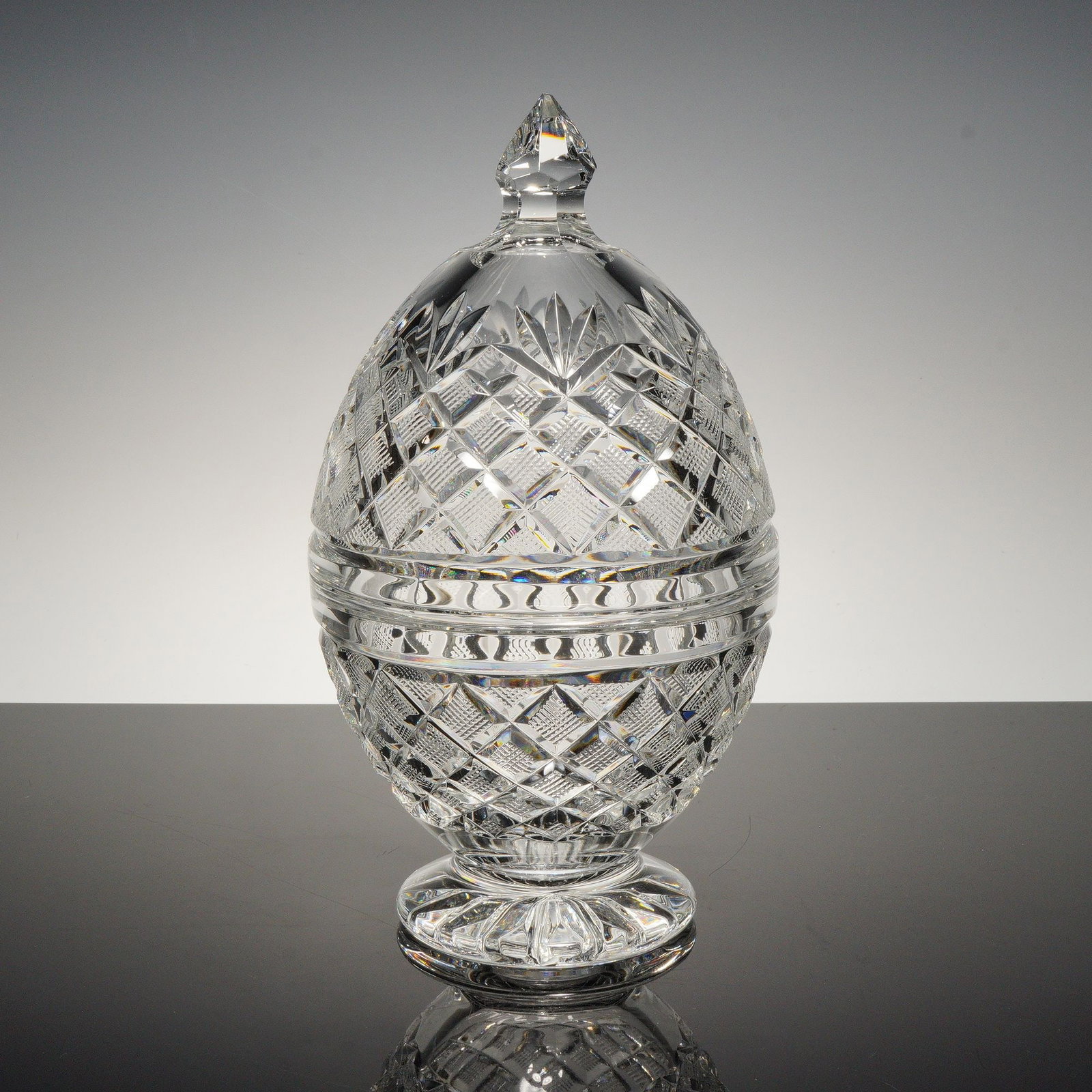 Waterford Crystal Bonbonniere, Ormonde: A finely crafted full-lead crystal bonbonniere in an elegant ovoid form, featuring intricate crosshatched and fan cuts that refract light with remarkable brilliance. The removable lid is surmounted by