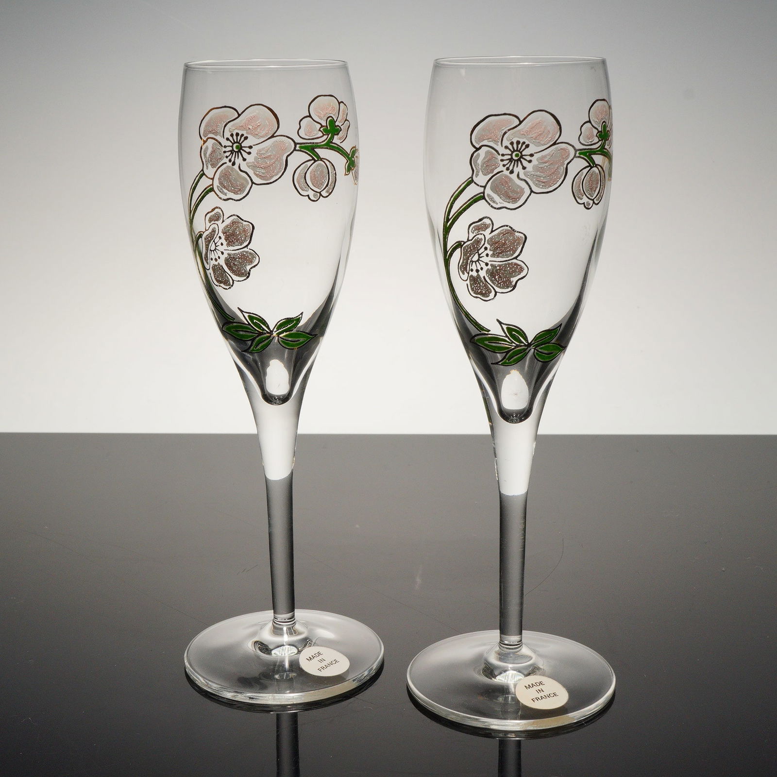 2pc Perrier Jouet Champagne Flutes Belle Epoque Pink Gold Flower: A beautiful matched pair of Perrier Jouet Belle Epoque champagne flutes, crafted in clear crystal and delicately adorned with the Maison's iconic Belle Epoque floral motif in shimmering pink and gold
