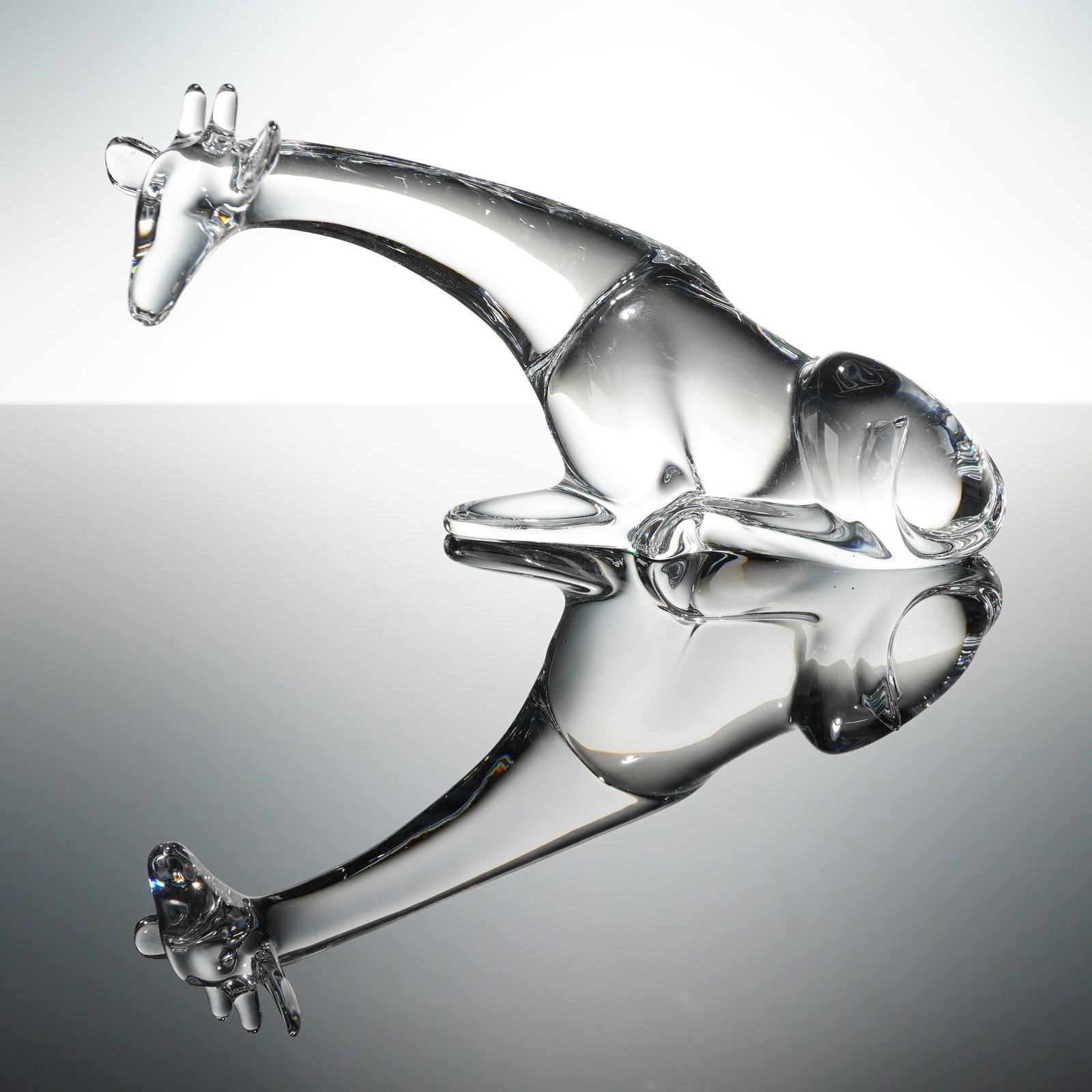 Baccarat Crystal Figurine by Loet Vanderveen, Giraffe: Clear crystal giraffe figurine by Baccarat, sculpted in a seated pose with an elongated neck and stylized contours. The form showcases Baccarat's refined glasswork and smooth, flowing lines. Etched Lo