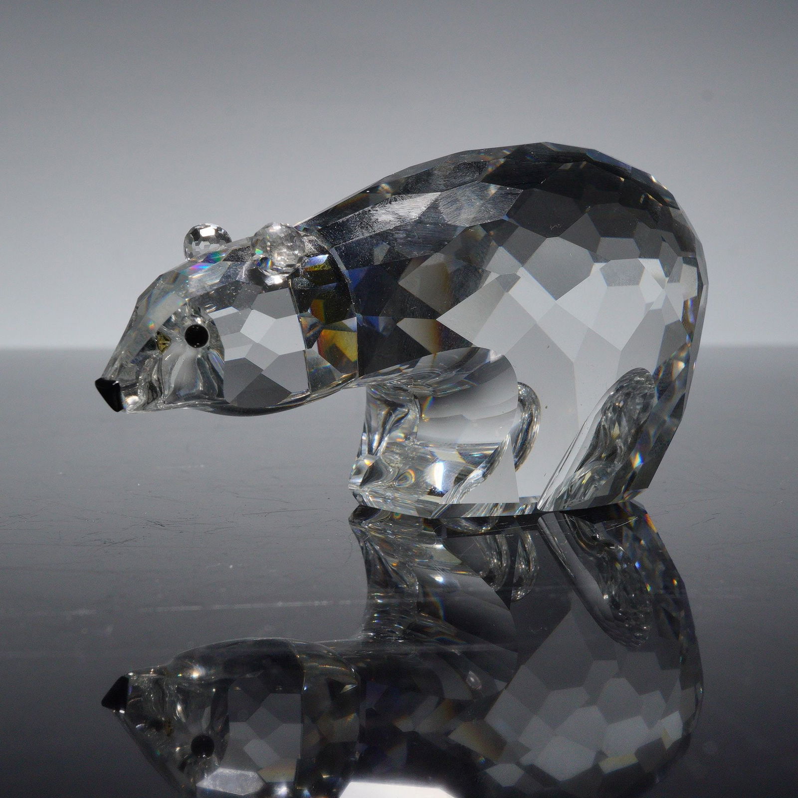 Swarovski Crystal Figurine, Polar Bear: A large, round polar bear standing sturdily with its head held high, showcasing its striking black crystal eyes. Swarovski swan backstamp. Artist: Adi Stocker Dimensions: 3.5"L x 1.5"W x 2"H Country o