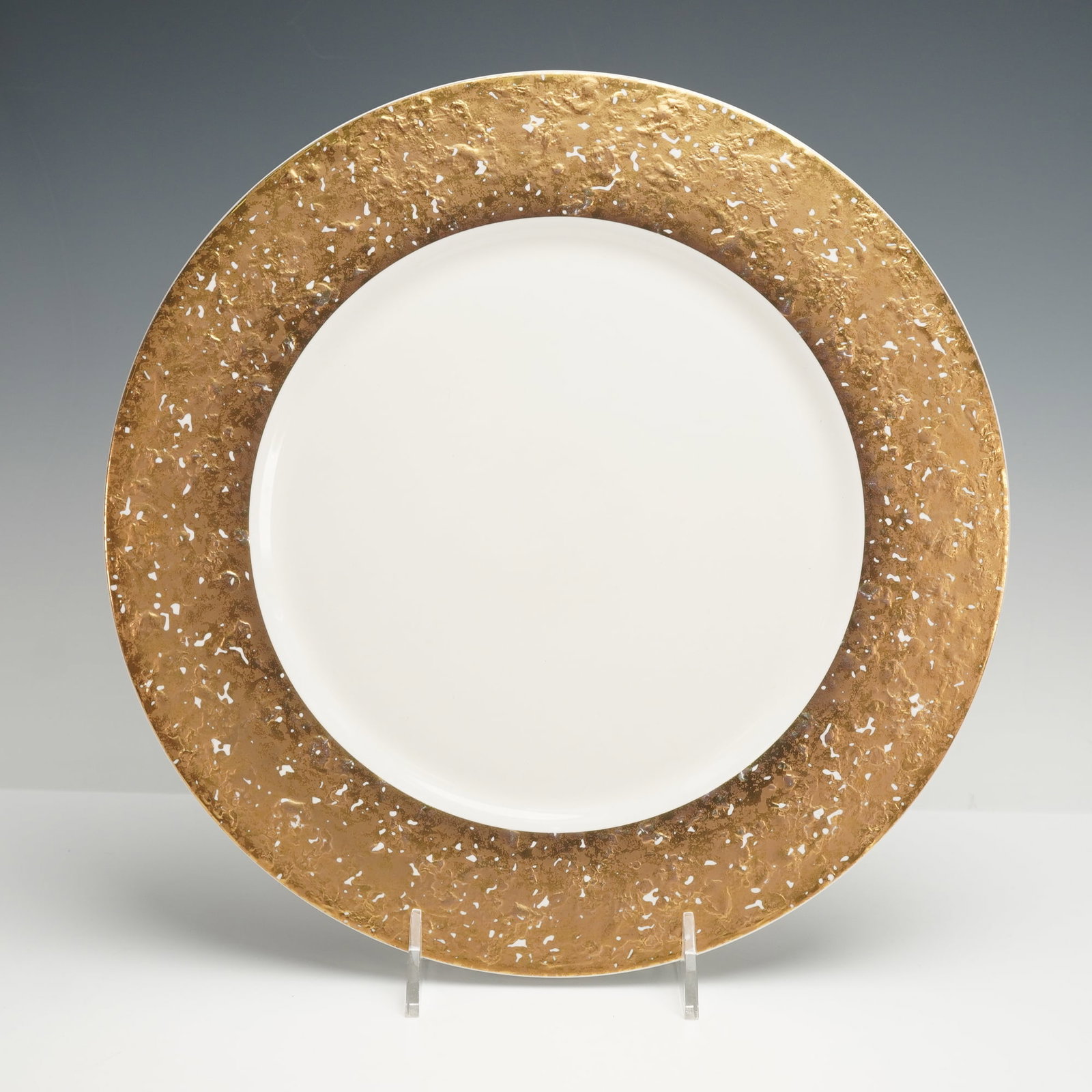 Pickard Gilded Charger Plate, Metropolitan: A round charger plate with a wide gilded border featuring an irregular textured pattern in gold and white. The center is smooth and white, creating a clear contrast with the metallic rim. Pickard back