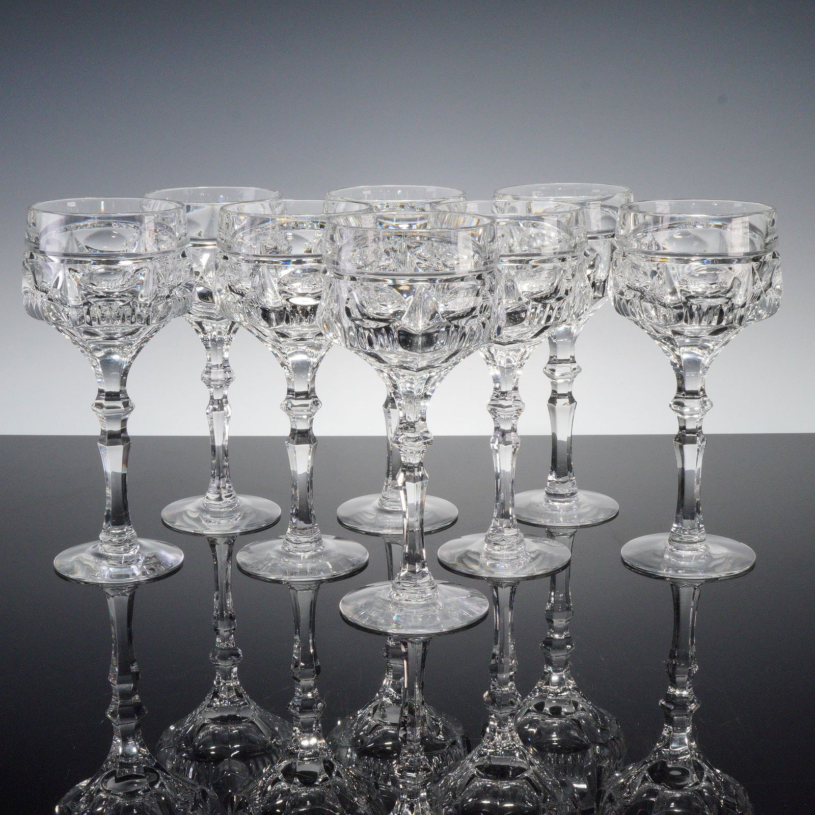 8pc Clear Cut Crystal Cocktail Coupe Glasses: Set of clear cut crystal cocktail coupes featuring faceted stems and geometric banding with prism and panel detail. Elegant and finely crafted, ideal for champagne or cocktail service. Dimensions: 8"H