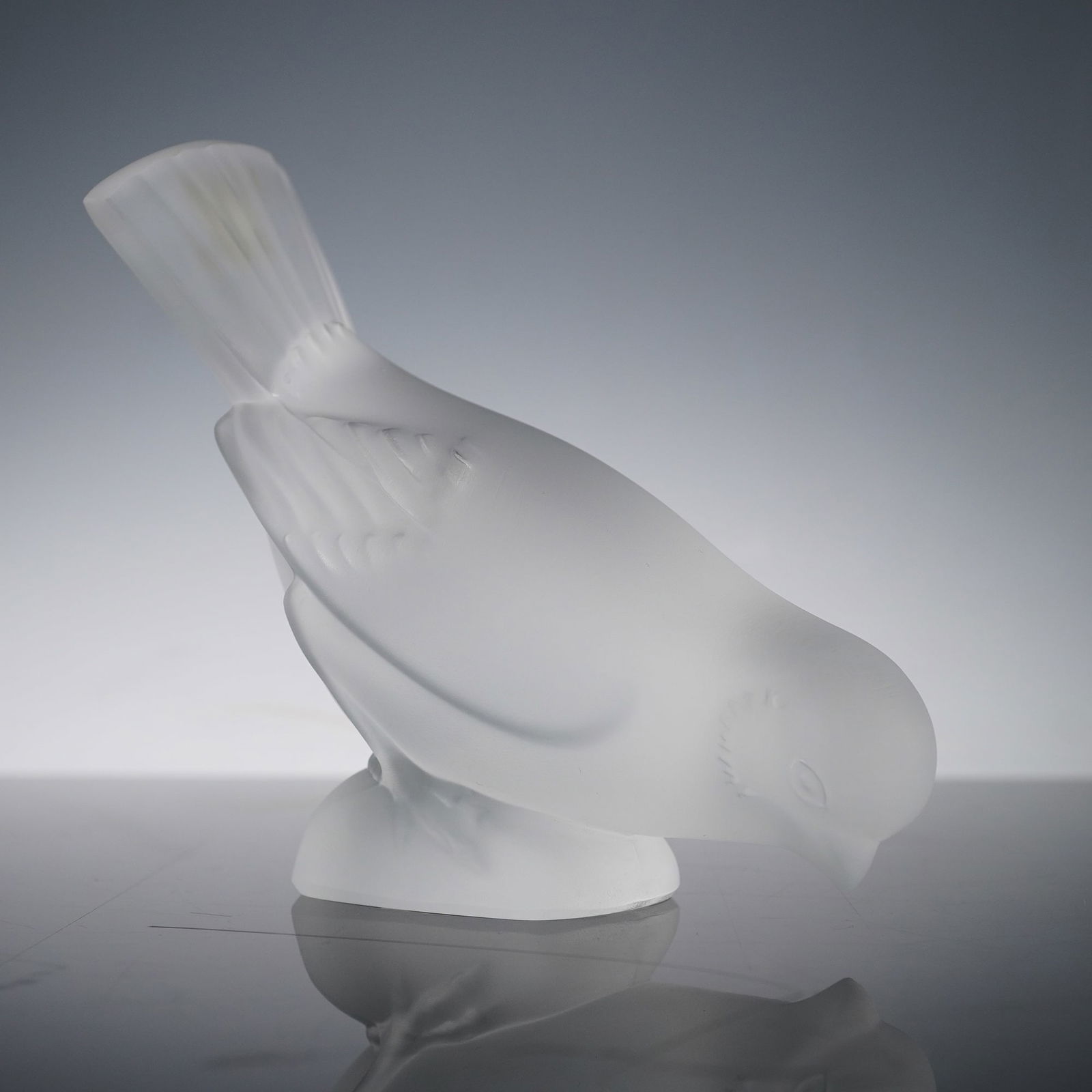 Lalique Satin Crystal Sparrow Paperweight: Finely modeled in the brand's signature satin-finish crystal. The delicate sculptural form depicts a sparrow with head bowed in naturalistic pose. Etched signature Lalique France to underside. Dimensi