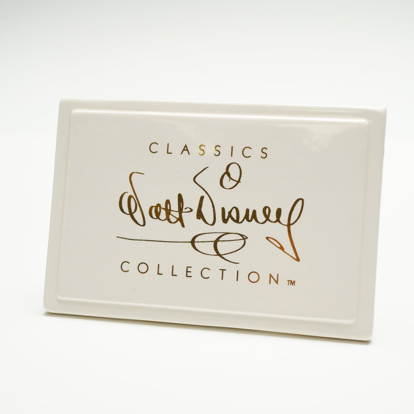Walt Disney Classics Collection Plaque: Ceramic plaque from the Walt Disney Classics Collection, featuring the gold script logo and text reading Classics Walt Disney Collection. Includes the original green and gold Walt Disney Studios Burba