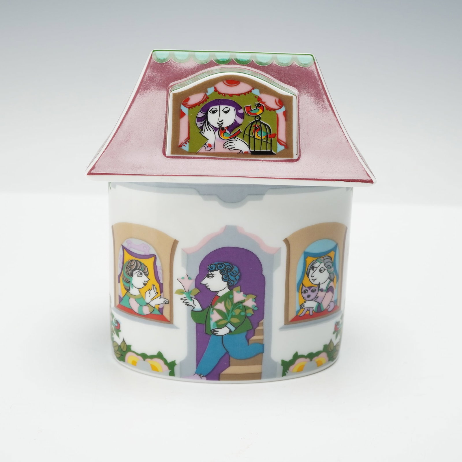 Rosenthal Studio Line Covered Box by Bjorn Wiinblad, Scenes from a Window: Covered box by Bjorn Wiinblad. The cylindrical box features Wiinblad's signature whimsical figures depicted in brightly colored vignettes of musicians, lovers, and artists framed within ornate window 