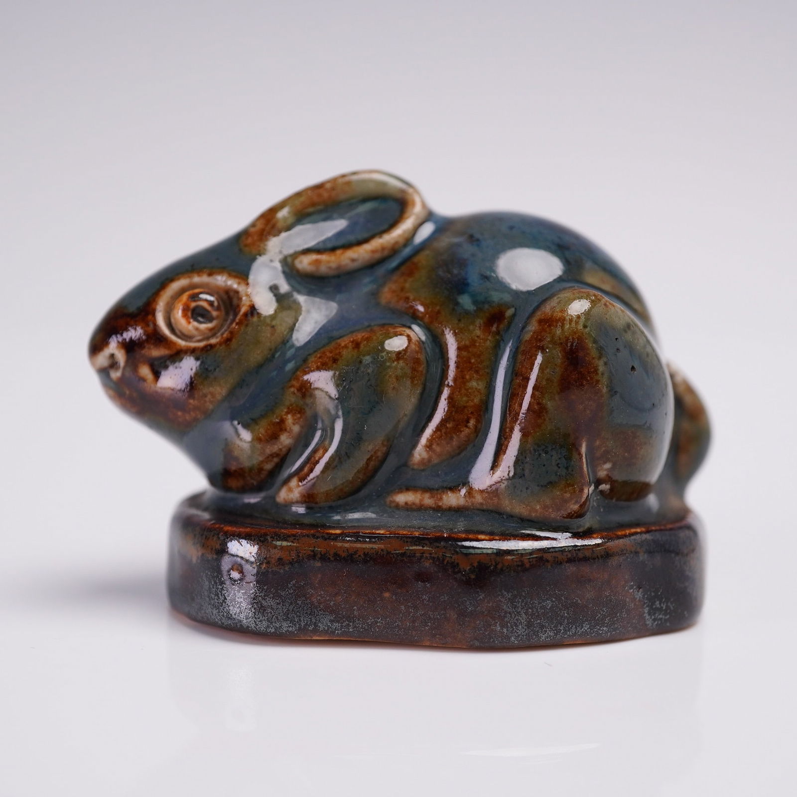 Royal Doulton Mark Marshall Stoneware Paperweight, Rabbit: A rare and collectible glazed figure of a rabbit designed by the esteemed Mark V. Marshall. This piece features a striking blue gray glaze that enhances the lifelike texture and fine details of the ra