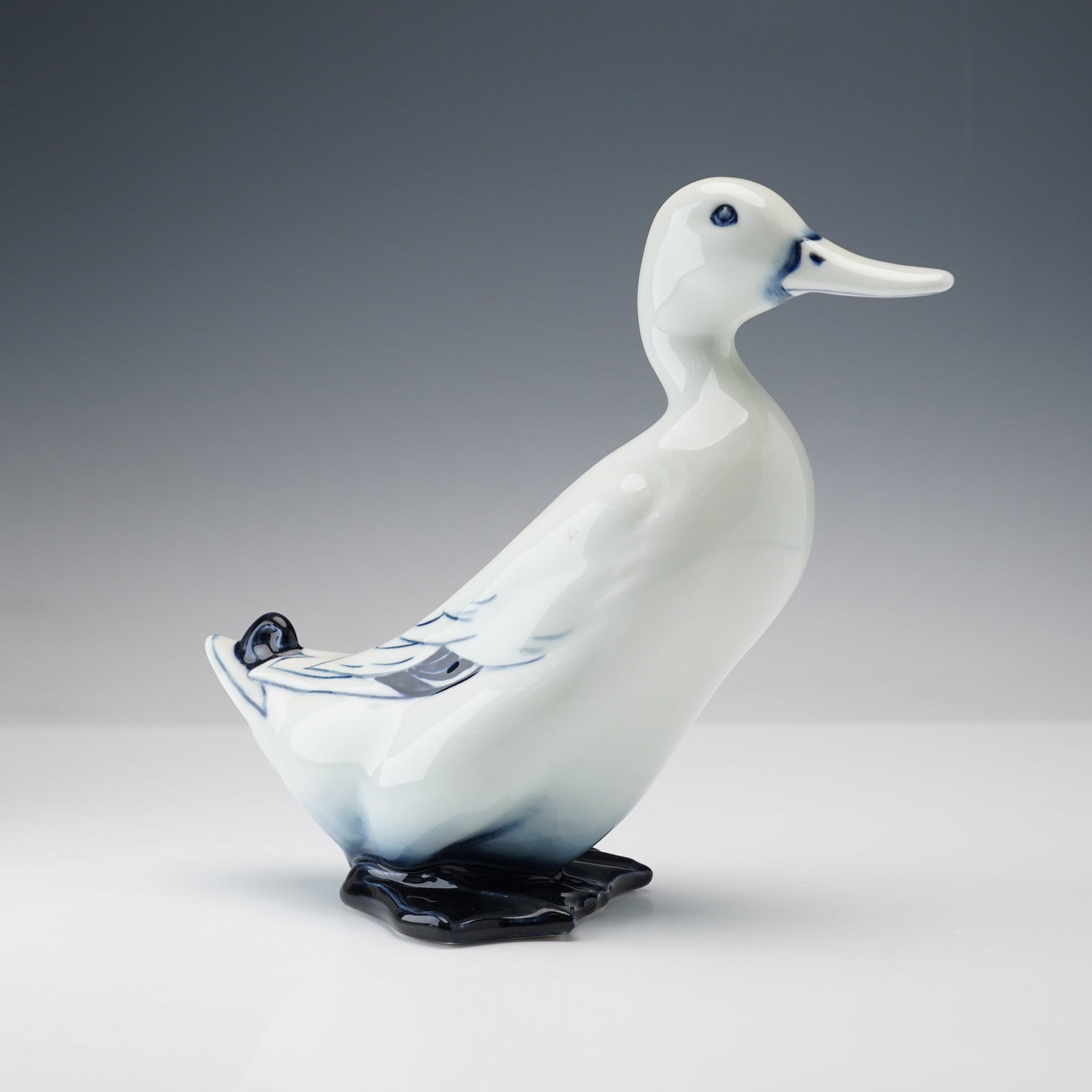 Royal Doulton Blue Flambe Figurine, Mallard Drake: A richly glazed porcelain depicting a mallard drake in elegant stylized form. The duck, finished in the distinctive Flambe technique with deep cobalt and soft gradient shading. Royal Doulton Flambe ba