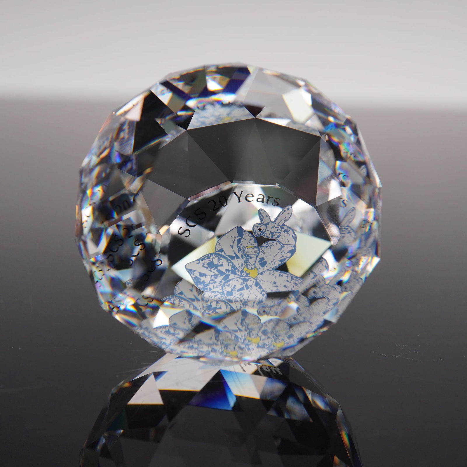 Swarovski Crystal SCS 20 Years 2007 Signing Event Paperweight: Brilliant Swarovski Crystal Society (SCS) 20 Years commemorative paperweight, issued in 2007 to celebrate two decades of SCS artistry and membership. The multi-faceted round crystal features a central