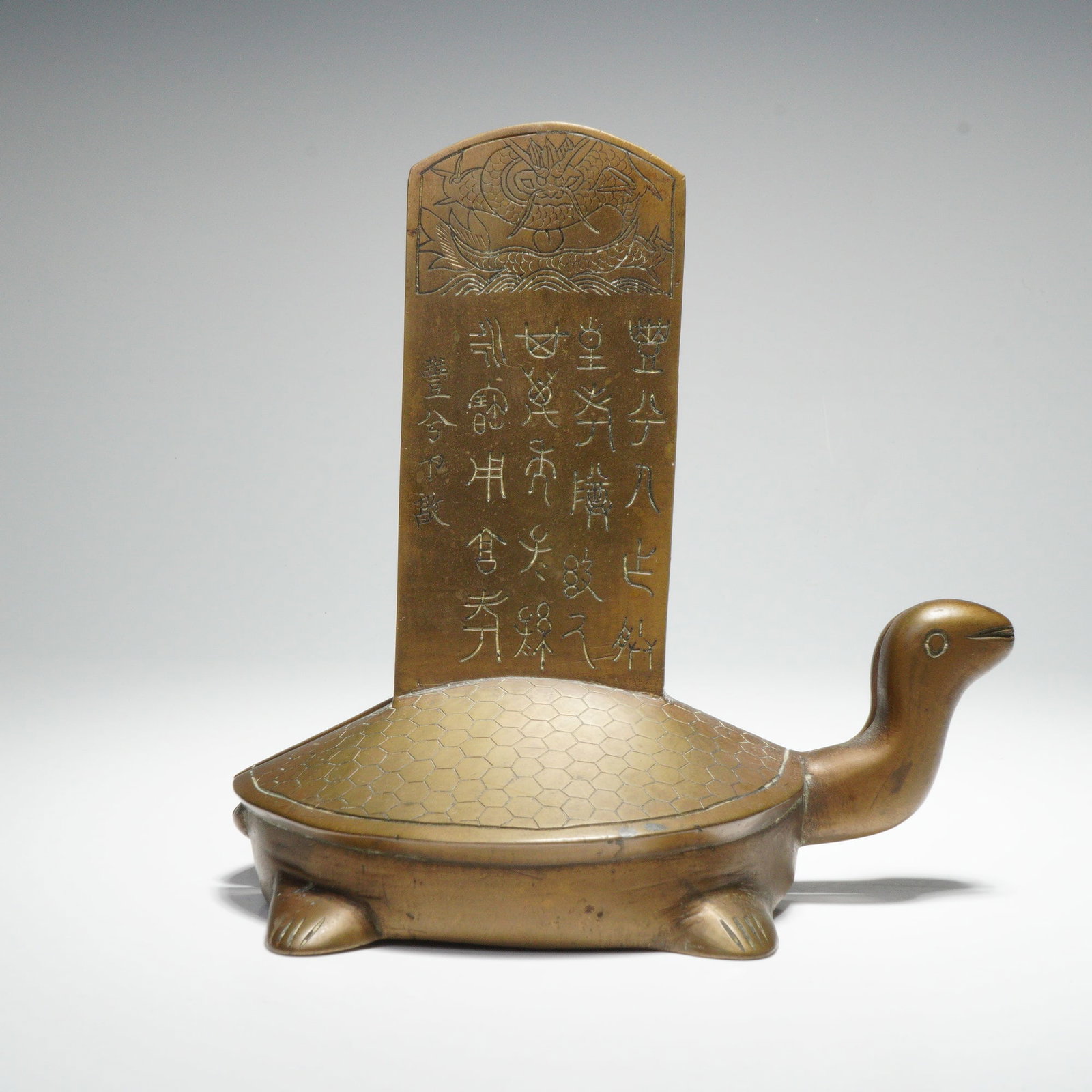 Pair of Chinese Cast Brass Turtle Bookends: Presented is a pair of cast brass bookends shaped as turtles supporting upright plaques. The plaques are engraved with Chinese characters rendered in an archaic seal-style script, showing the angular