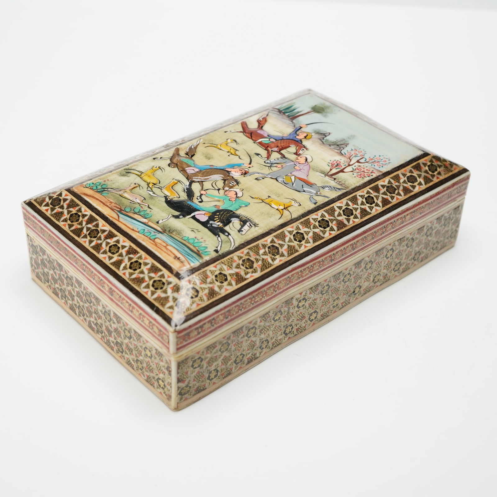 Persian-Style Hand-Painted Decorative Box, Hunting Scene: A rectangular decorative box inspired by traditional Persian miniature painting and Khatam-style geometric inlay. The lid features a vivid hand-painted hunting scene with riders, hounds, and wildlife