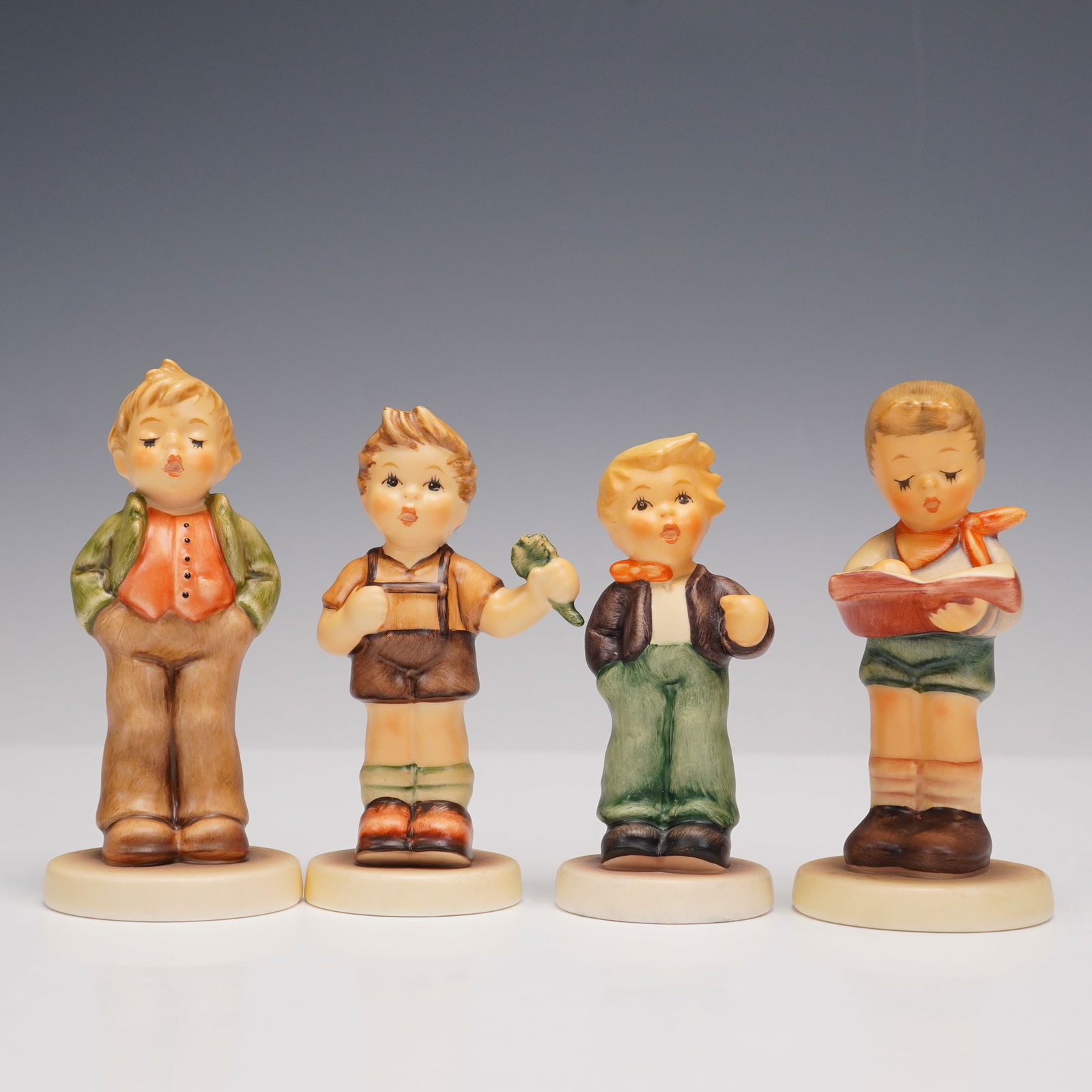4pc Goebel Hummel Boyhood Memories Figurines: 4-piece collection of Goebel Hummel porcelain figurines, including Steadfast Soprano (848), A Four-Leaf Clover (2068), A Flower for You (2077/B), and Honor Student (2087/B). Each figure is hand-painte