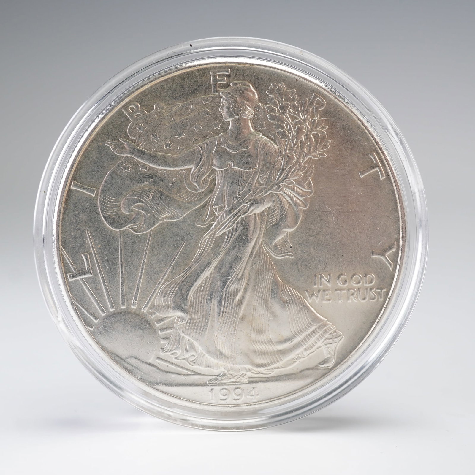 1994 American Silver Eagle One Ounce $1 Coin: This 1994 American Silver Eagle coin contains one troy ounce of .999 fine silver. The obverse depicts Liberty striding toward the sunrise, draped in the American flag and carrying laurel and oak branc