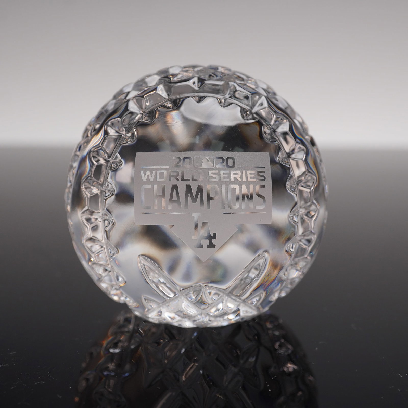 Waterford Crystal 2020 World Series Champions Baseball Paperweight: Celebrating the Los Angeles Dodgers as the 2020 World Series Champions. Expertly crafted in the shape of a baseball, this limited edition paperweight features intricate cut crystal detailing and an et