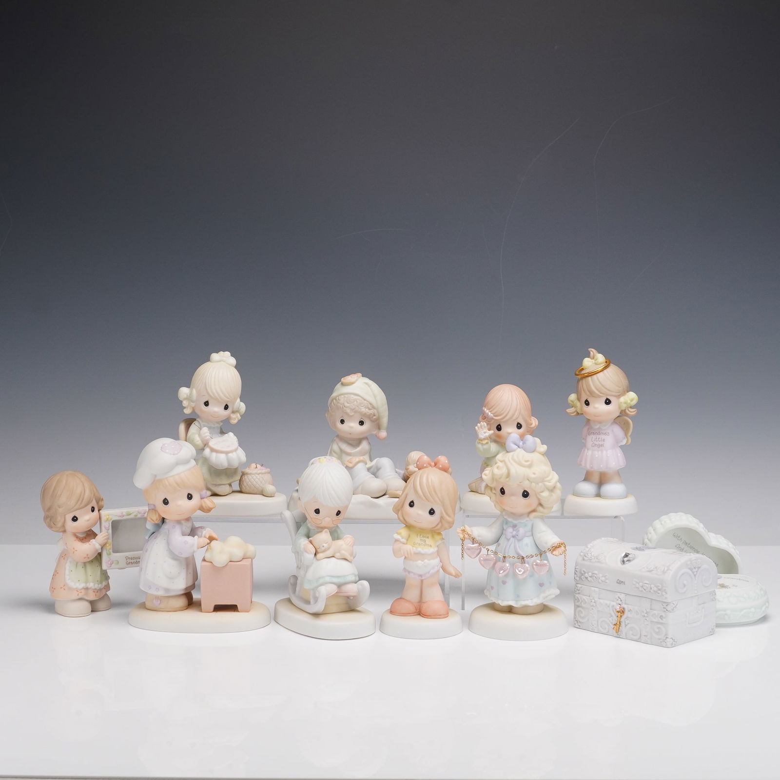 11pc Precious Moments Figurines and Jewelry Boxes: A charming collection of Precious Moments pieces including ten figurines and two decorative boxes. The figurines feature Grandmas Little Angel, Pizza on Earth, You Have Touched So Many Hearts, Mother